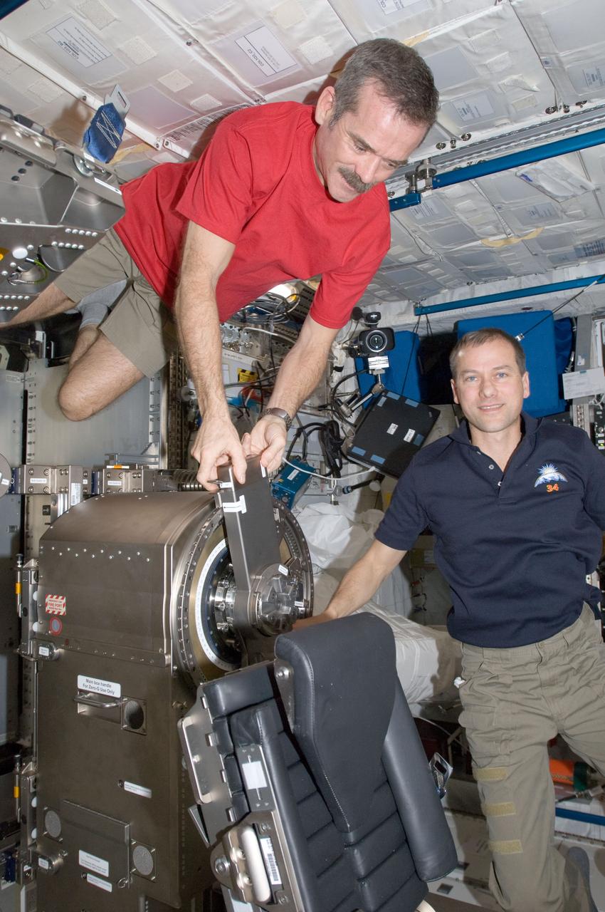 ISS034-E-014618 (3 Jan. 2013) --- Canadian Space Agency astronaut Chris Hadfield (left) and NASA astronaut Tom Marshburn, both Expedition 34 flight engineers, work with Muscle Atrophy Resistive Exercise System (MARES) hardware in the Columbus laboratory of the International Space Station.