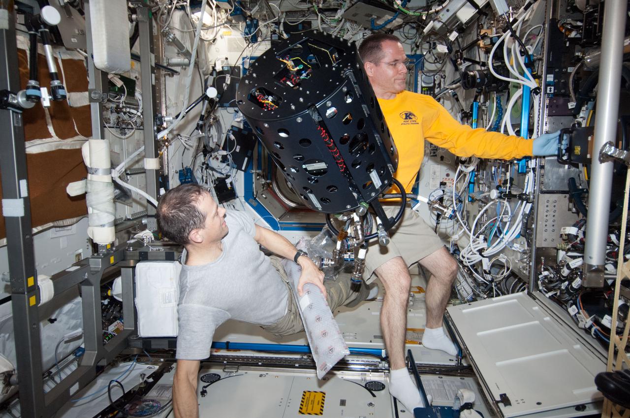 ISS034-E-023543 (9 Jan. 2013) --- NASA astronauts Kevin Ford (right), Expedition 34 commander; and Tom Marshburn, flight engineer, work with the Combustion Integrated Rack (CIR) Multi-user Droplet Combustion Apparatus (MDCA) in the International Space Station's Destiny laboratory.
