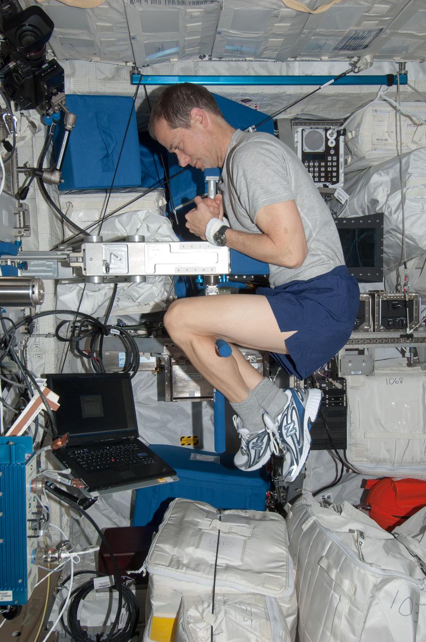 ISS034-E-026654 (11 Jan. 2013) --- NASA astronaut Tom Marshburn, Expedition 34 flight engineer, uses the Space Linear Acceleration Mass Measurement Device (SLAMMD) in the Columbus laboratory of the International Space Station.