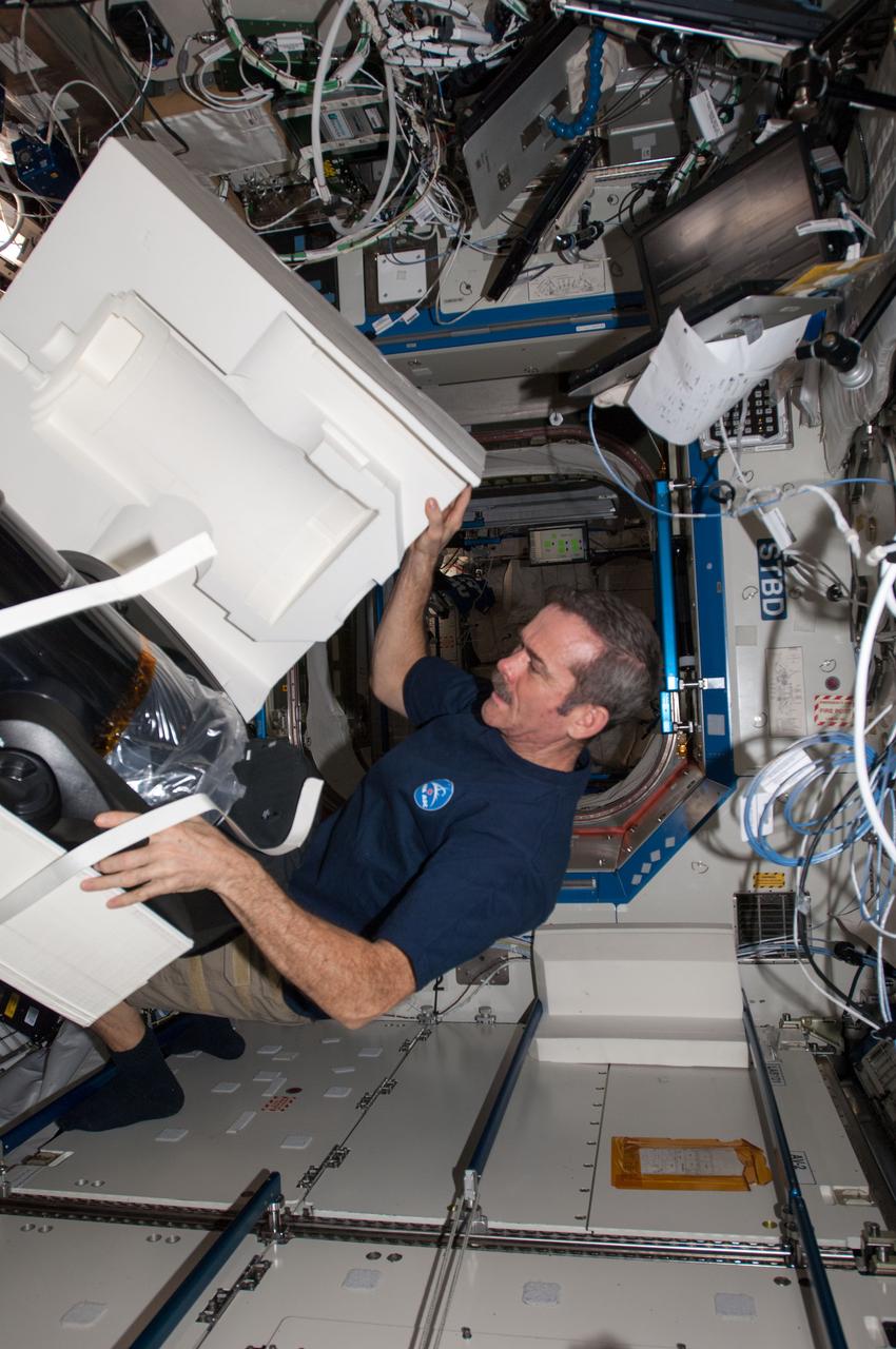 ISS034-E-029954 (15 Jan. 2013) --- Canadian Space Agency astronaut Chris Hadfield, Expedition 34 flight engineer, prepares to set up the ISS SERVIR Environmental Research and Visualization System (ISERV) in the Destiny laboratory of the International Space Station. ISERV is a fully automated image data acquisition system that flies aboard the space station and deploys in the Window Observational Research Facility (WORF) rack within Destiny. The study is expected to provide useful images for use in disaster monitoring and assessment and environmental decision making.