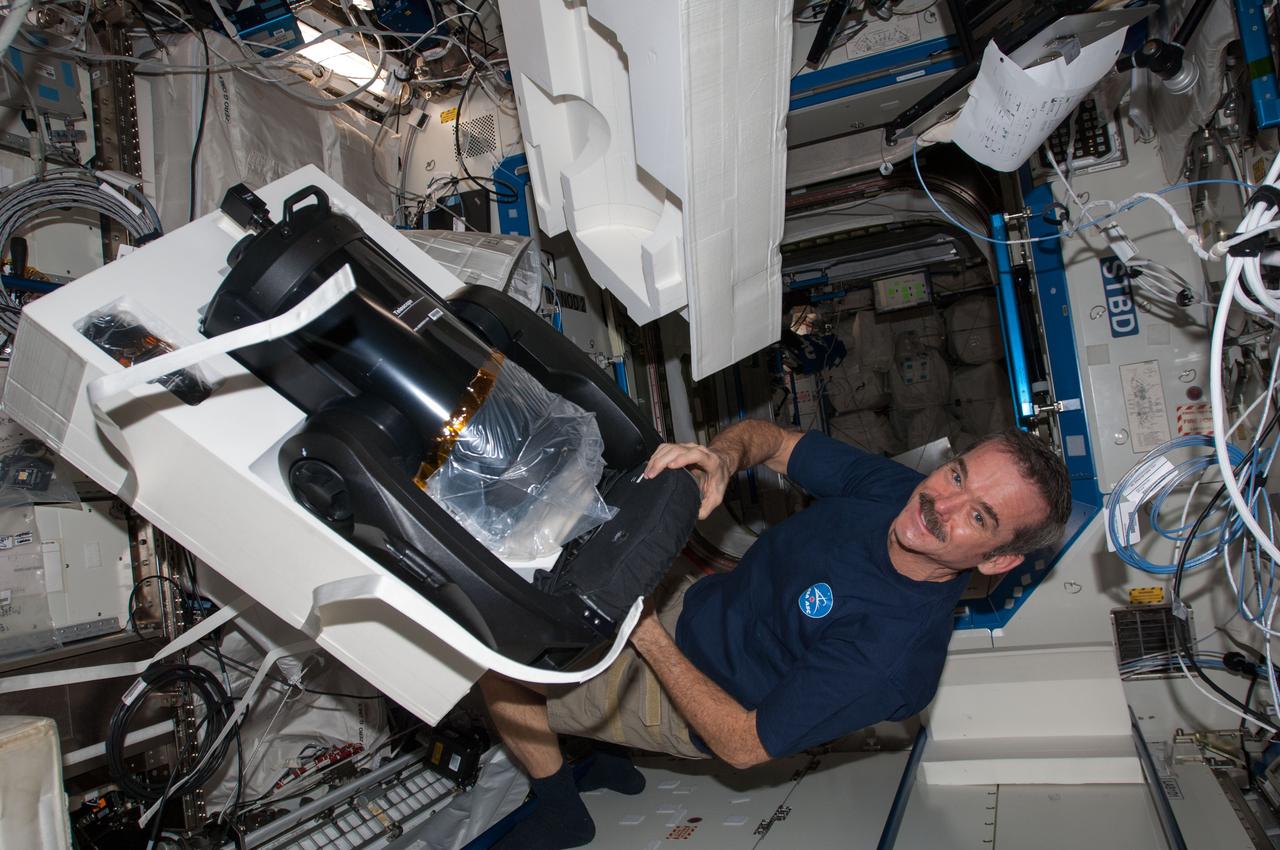View of Canadian Space Agency (CSA) Chris Hadfield,Expedition 34 Flight Engineer (FE),unpacking ISS SERVIR Environmental Research and Visualization System (ISERV) in the U.S. Laboratory. ISERV is a fully automated image data acquisition system in the Window Observational Research Facility (WORF) rack. Kevin Ford,Expedition 34 Commander is visible on the right of frame. Photo was taken during Expedition 34.