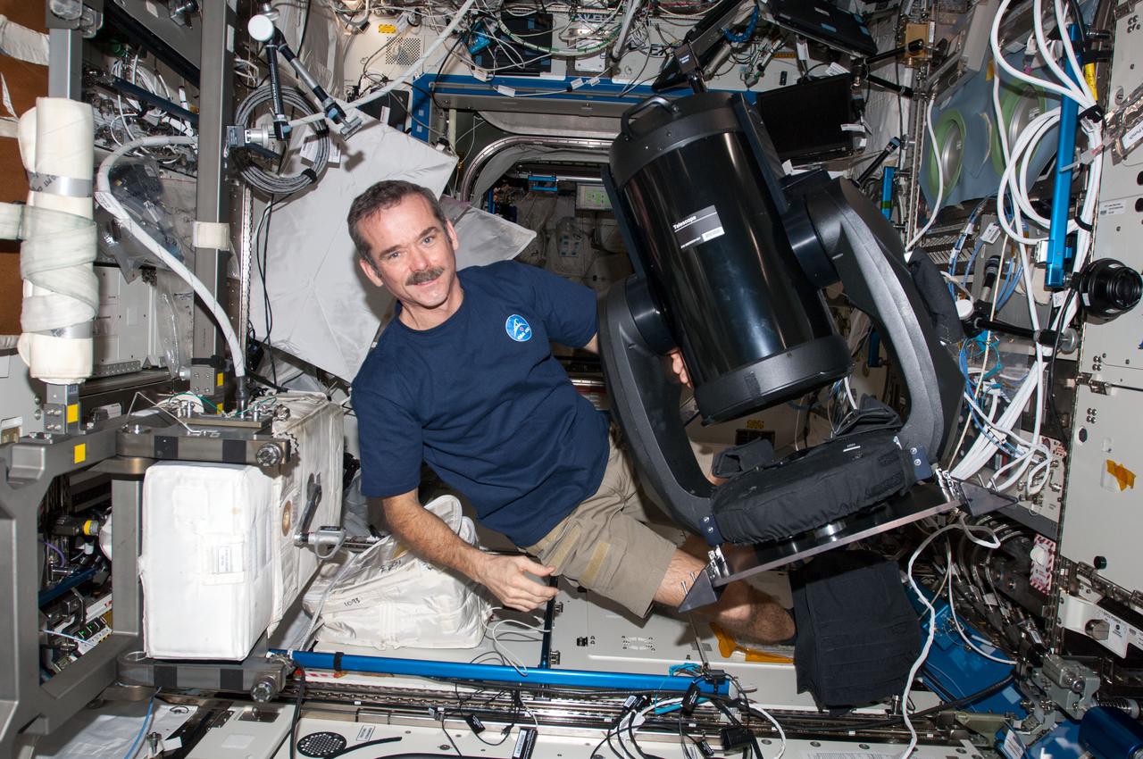 View of Canadian Space Agency (CSA) Chris Hadfield,Expedition 34 Flight Engineer (FE), preparing to setup the ISS SERVIR Environmental Research and Visualization System (ISERV) in the U.S. Laboratory. ISERV is a fully automated image data acquisition system in the Window Observational Research Facility (WORF) rack. Kevin Ford,Expedition 34 Commander is visible on the right of frame. Photo was taken during Expedition 34.