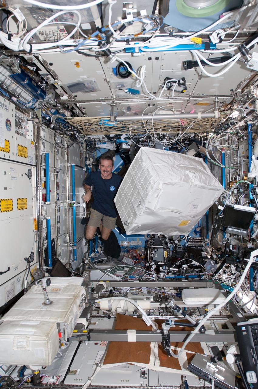ISS034-E-029995 (15 Jan. 2013) --- Canadian Space Agency astronaut Chris Hadfield, Expedition 34 flight engineer, moves a stowage container in the Destiny laboratory of the International Space Station.
