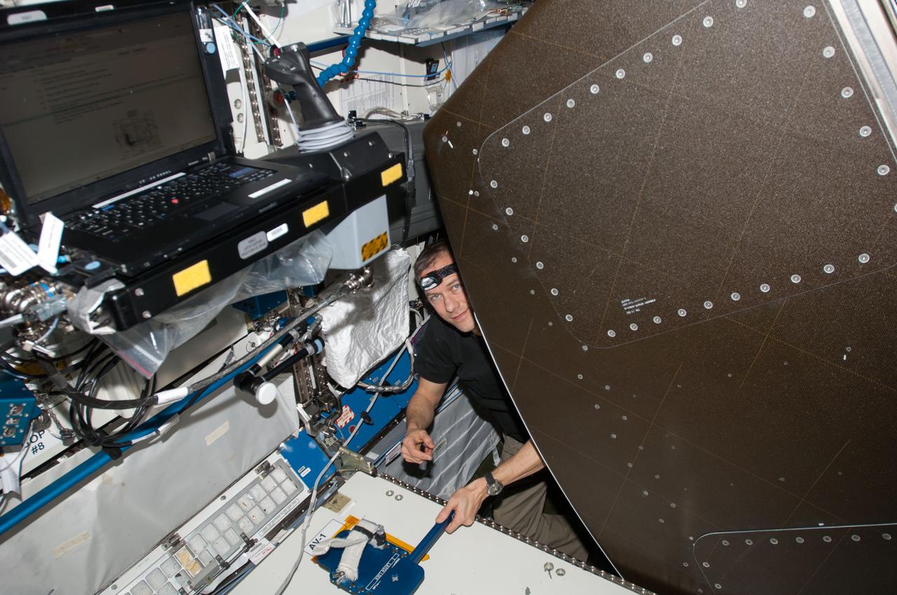 ISS034-E-030206 (16 Jan. 2013) --- NASA astronaut Tom Marshburn, Expedition 34 flight engineer, works behind a rack in the Destiny laboratory of the International Space Station.