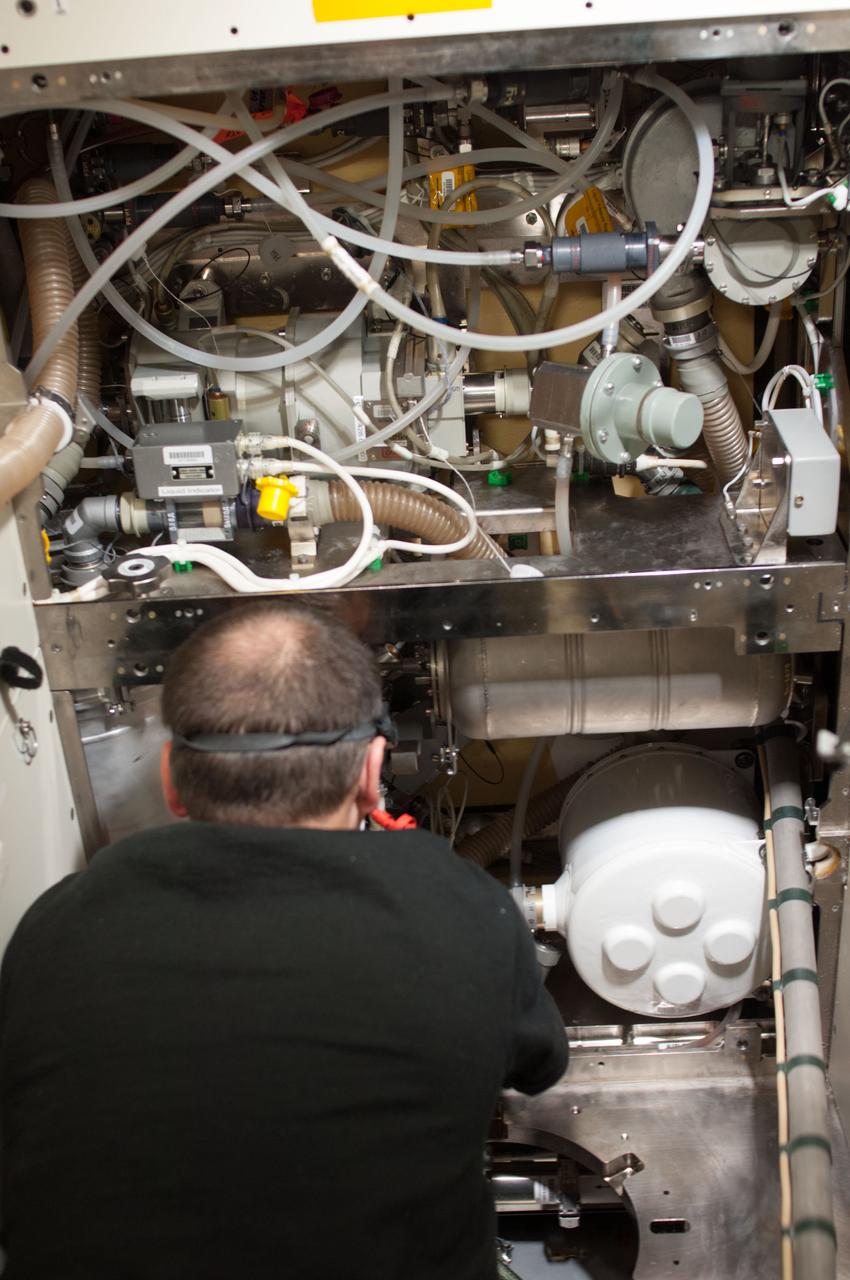 ISS034-E-031142 (3 Jan. 2013) --- NASA astronaut Tom Marshburn, Expedition 34 flight engineer, removes and replaces the Waste and Hygiene Compartment (WHC) piping during routine in-flight maintenance in the Tranquility node of the International Space Station.
