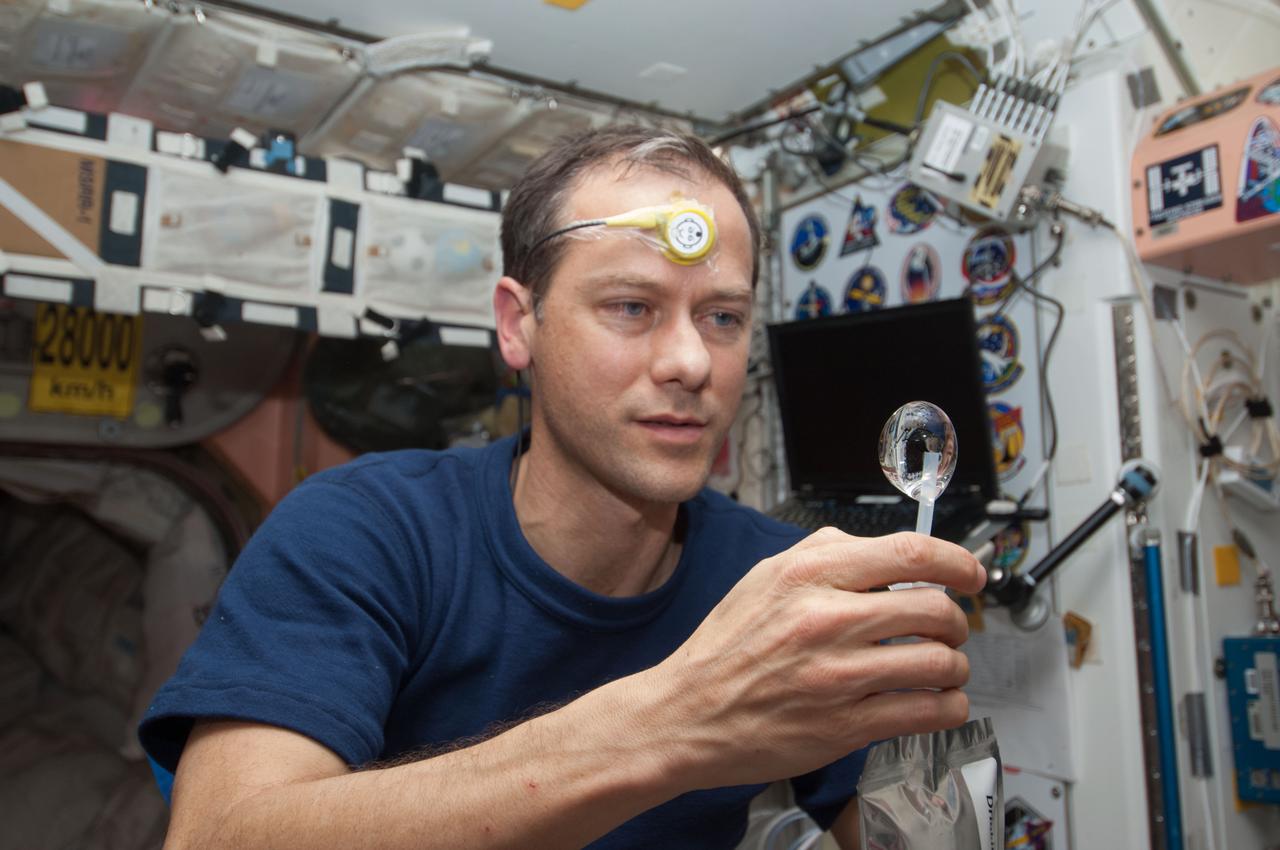 ISS034-E-031709 (21 Jan. 2013) --- NASA astronaut Tom Marshburn, Expedition 34 flight engineer, squeezes a water bubble out of his beverage container in the Unity node of the International Space Station. He is wearing a Drager Double Sensor on his forehead which is used on the Circadian Rhythms Experiment. This experiment examines the hypothesis that long-term spaceflights significantly affect the synchronization of the circadian rhythms in humans due to changes of a non-24 hour light-dark cycle.