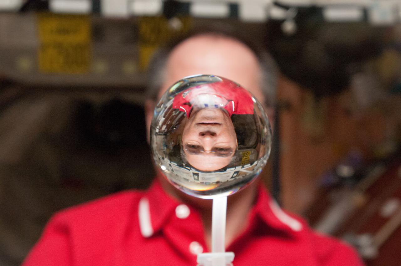 ISS034-E-031855 (21 Jan. 2013) --- NASA astronaut Kevin Ford, Expedition 34 commander, watches a water bubble float freely between him and the camera, showing his image refracted, in the Unity node of the International Space Station.