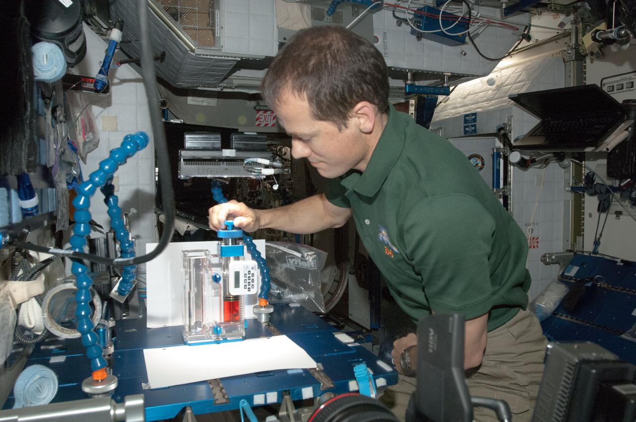 ISS034-E-036840 (29 Jan. 2013) --- In the International Space Station?s Harmony node, NASA astronaut Tom Marshburn, Expedition 34 flight engineer, works with the Capillary Flow Experiment-3, which investigates how fluids flow across surfaces in a weightless environment. Results from this experiment will improve computer models used to design fluid transfer systems and fuel tanks on future spacecraft.