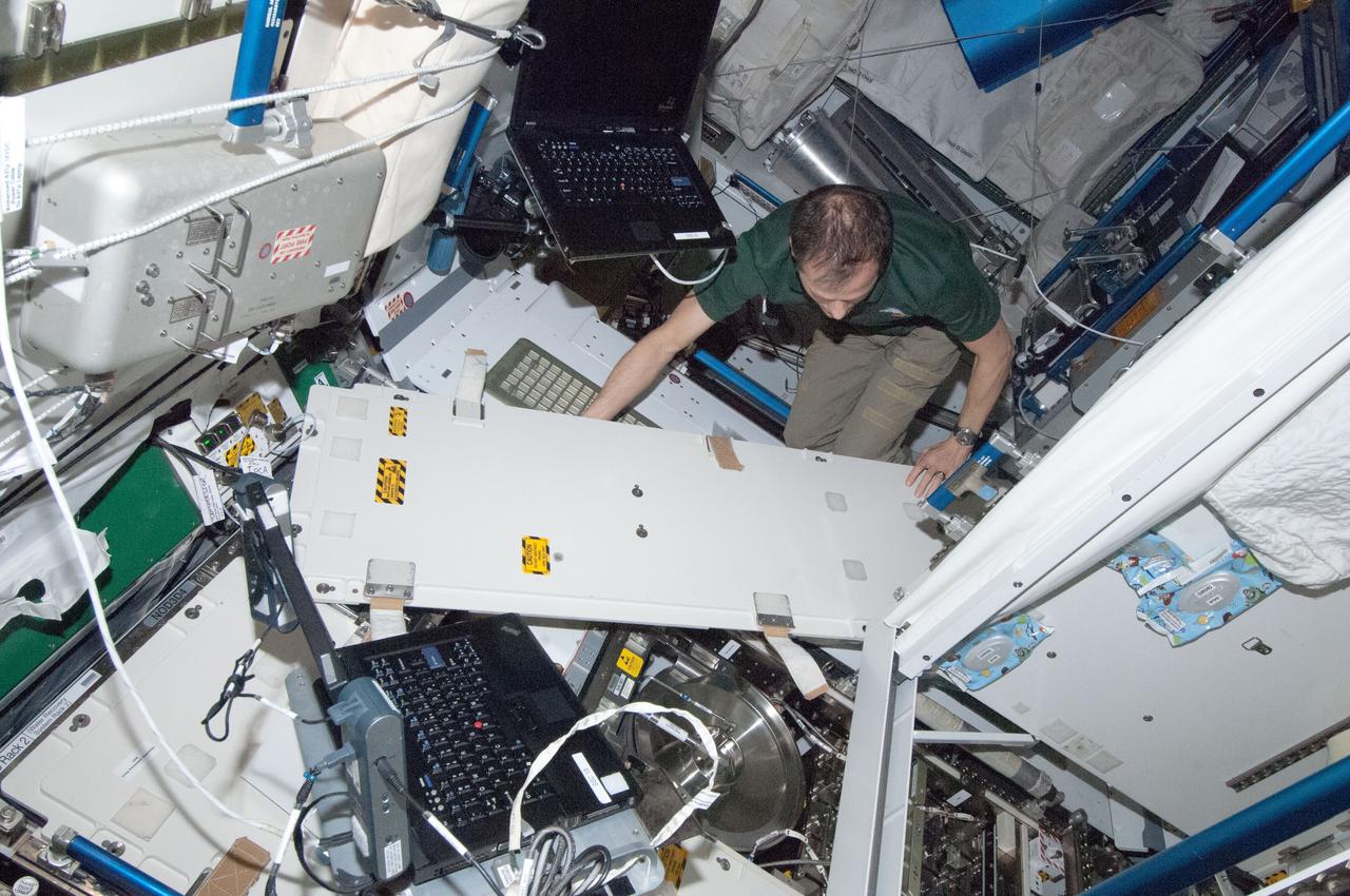 ISS034-E-045742 (11 Feb. 2013) --- NASA astronaut Tom Marshburn, Expedition 34 flight engineer, removes and replaces the Waste and Hygiene Compartment (WHC) pretreat tank as part of routine in-flight maintenance in the Tranquility node of the International Space Station.