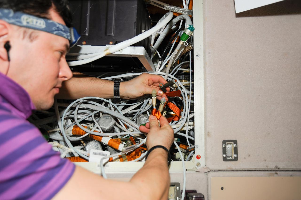 ISS034-E-051750 (22 Feb. 2013) --- Russian cosmonaut Roman Romanenko, Expedition 34 flight engineer, works with connections related to communications systems in the Zvezda service module onboard the International Space Station in Earth orbit.
