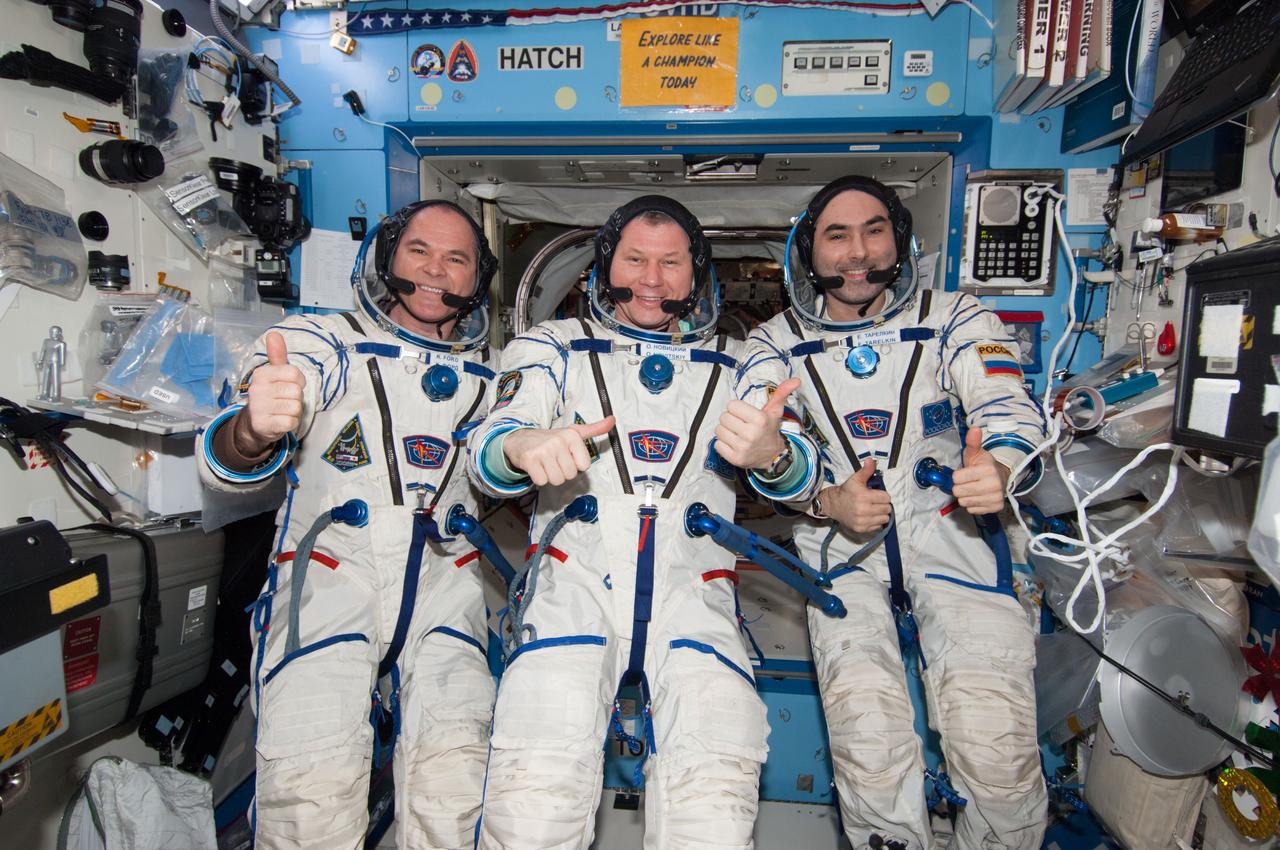 ISS034-E-061657 (5 March 2013) --- With their scheduled stay onboard the International Space Station headed toward its final days, three members of the Expedition 34 crew pose for some  photographs in their Sokol suits in the U.S. lab or Destiny. From left are NASA astronaut Kevin Ford, commander; with Roscosmos Flight Engineers Oleg Novitskiy and Evgeny Tarelkin.  Two days earlier, the trio joined crew members from Russia, the U.S. and Canada in welcoming the arrival of fresh food and supplies aboard the SpaceX Dragon spacecraft.
