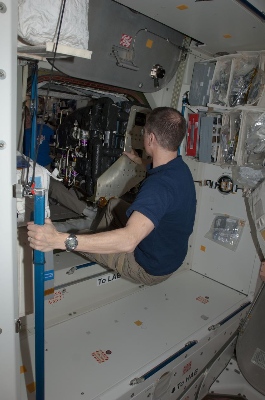 ISS034-E-063091 (9 March 2013) --- NASA astronauts Tom Marshburn, Expedition 34 flight engineer, and Kevin Ford (background), Expedition 34 commander, move the Carbon Dioxide Removal Assembly through U.S. Laboratory (Destiny) hatch on the Earth-orbiting International Space Station.