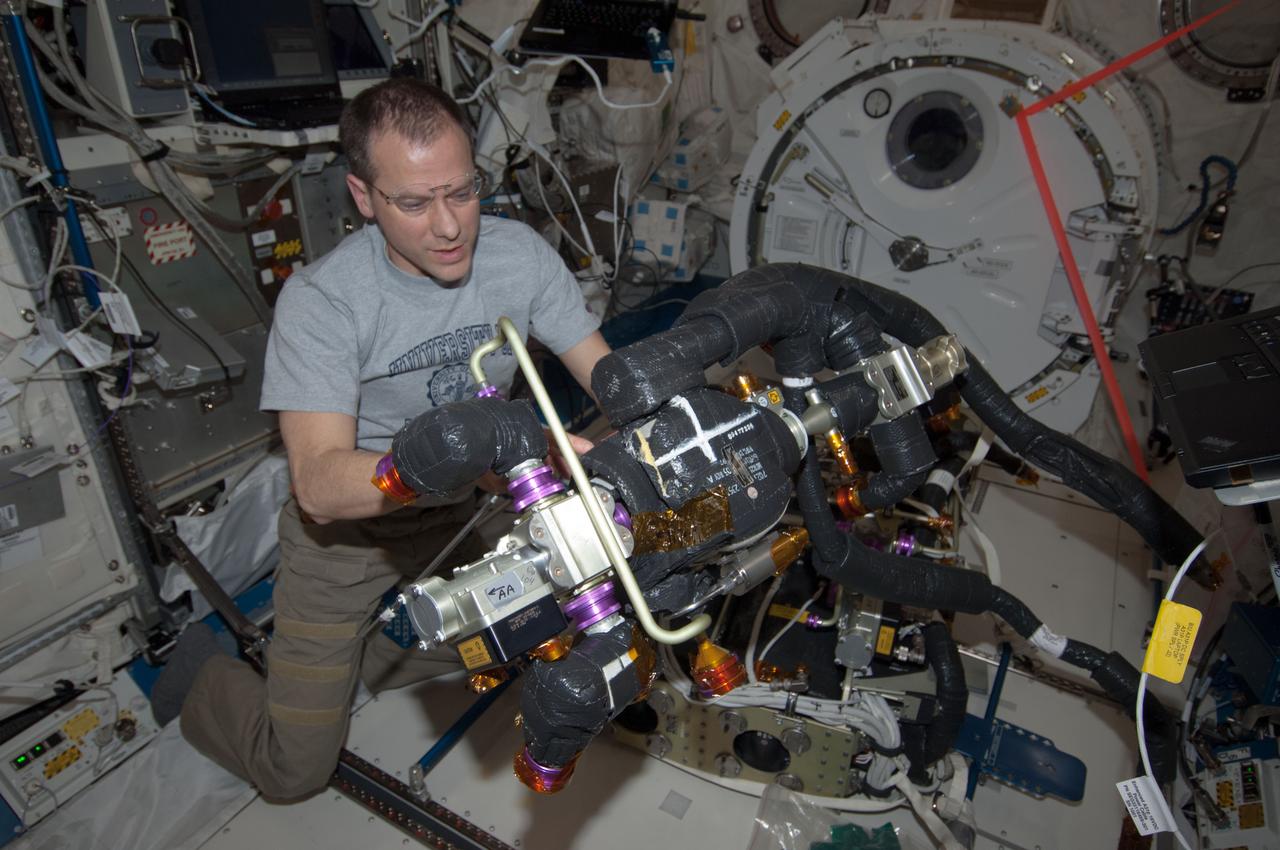 ISS034-E-063336 (8 March 2013) --- NASA astronaut Tom Marshburn, Expedition 34 flight engineer, performs maintenance on the Carbon Dioxide Removal Assembly in the Japanese Experiment Module (JEM) Pressurized Module (JPM).