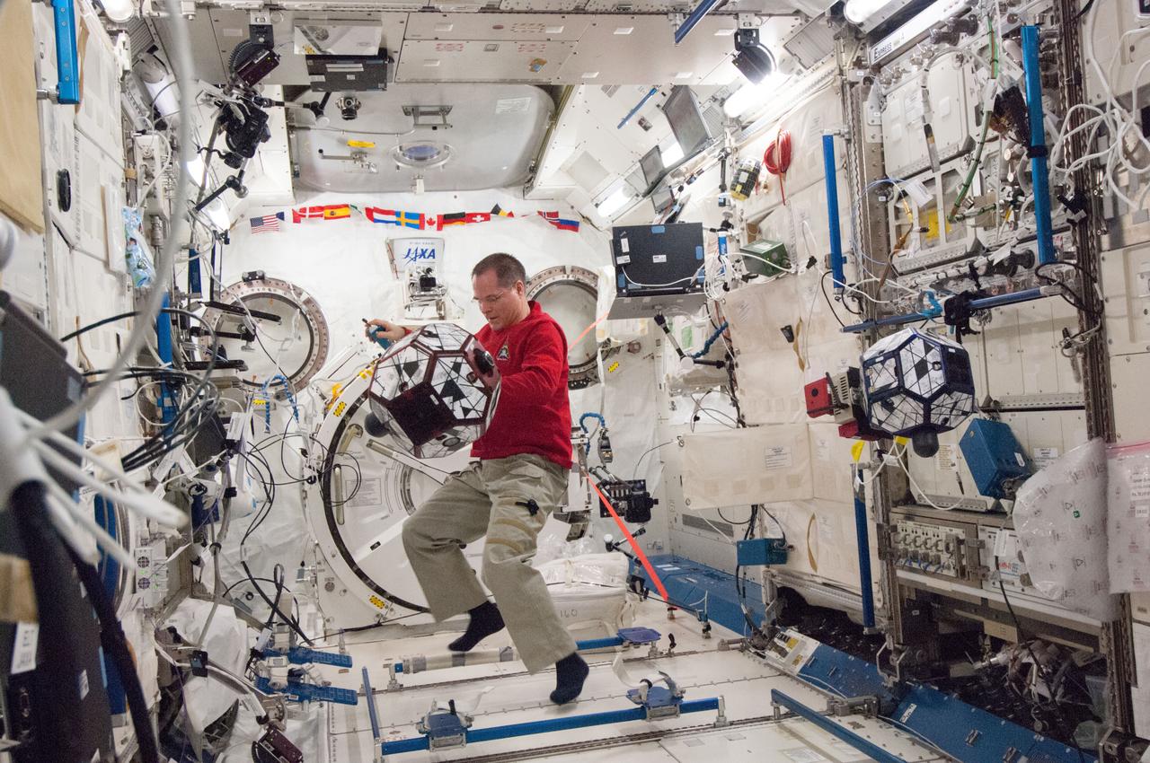 ISS034-E-067585 (12 March 2013) --- Inside the Japan Aerospace Exploration Agency's (JAXA) Kibo lab on the Earth-orbiting International Space Station, NASA astronaut Kevin Ford, Expedition 34 commander, conducts a session of the ongoing SPHERES-VERTIGO investigation. SPHERES stands for Synchronized Position Hold, Engage, Reorient Experimental Satellites. Each satellite is an 18-sided polyhedron that is 0.2 meter in diameter and weighs 3.5 kilograms. The prism-shaped device (called Goggles) which is easily seen hooked up to the polyhedron on the right in this picture is called Visual Estimation and Relative Tracking for Inspection of Generic Objects (VERTIGO).