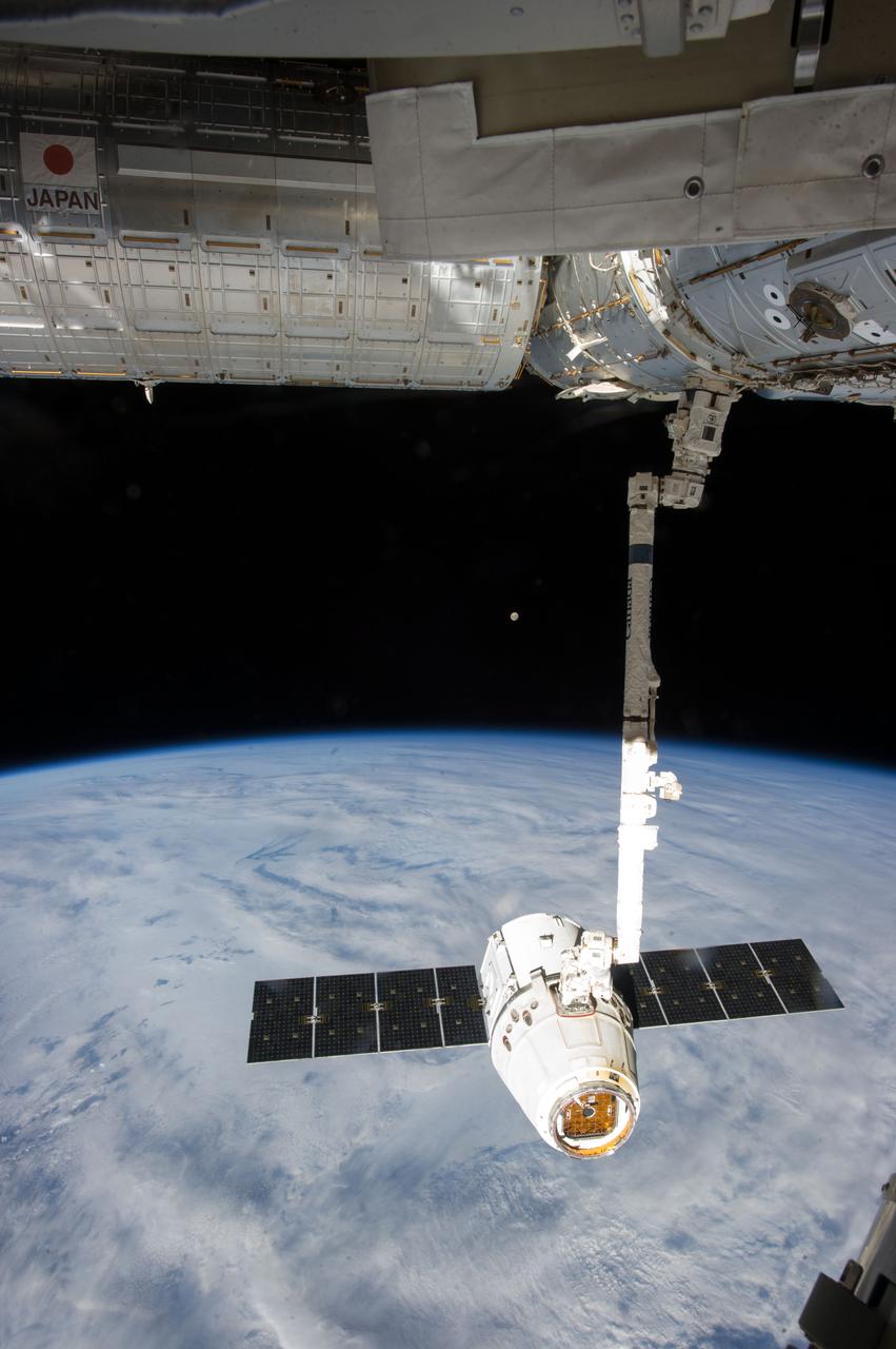 ISS035-E-008927 (26 March 2013) ---This image is one of a series of still photos documenting the process to release the SpaceX Dragon-2 spacecraft from the International Space Station on March 26.  The spacecraft, filled with experiments and old supplies, can be seen in the grasp of the Space Station Remote Manipulator System’s robot arm or CanadArm2 after it was undocked from the orbital outpost.  The Dragon was scheduled to make a landing in the Pacific Ocean, off the coast of California, later in the day.