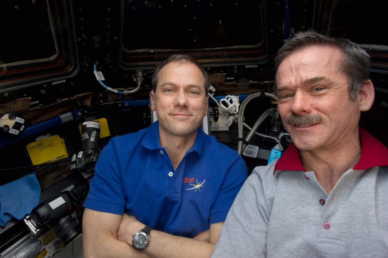 ISS035-E-008937 (26 March 2013) --- Expedition 35 Commander Chris Hadfield (right) of the Canadian Space Agency and Flight Engineer Tom Marshburn of NASA are pictured in the Cupola on the International Space Station during the operations that ultimately led to the release of the SpaceX Dragon-2 spacecraft for its return to Earth after a three-week stay aboard the orbital outpost. The Dragon was scheduled to make a landing in the Pacific Ocean, off the coast of California, later in the day.