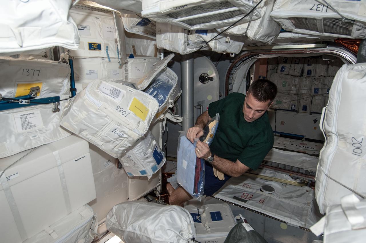 ISS035-E-010424 (30 March 2013) --- NASA astronaut Chris Cassidy, Expedition 35 flight engineer, works with the loading and unloading of supplies in the Leonardo Permanent Multipurpose Module (PMM) of the Earth-orbiting International Space Station.
