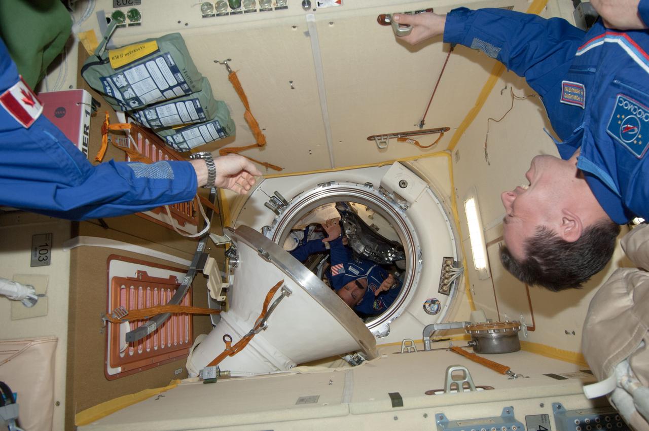 ISS035-E-010761 (29 March 2013) --- Expedition 35 Commander Chris Hadfield of the Canadian Space Agency, whose stretched-out arm can be seen at upper left, was expecting to see NASA astronaut Chris Cassidy float into this scene in the Poisk or Mini-Research Module 2 (MRM2), but he might have been somewhat surprised to see the exaggerated mustache which Cassidy was sporting. Cosmonaut and Expedition 35 Flight Engineer Roman Romanenko is at right.  Cassidy and two crewmates had earlier arrived at the orbital outpost by way of the Soyuz TMA-08M spacecraft.  One would imagine that Hadfield, who has a real mustache, likely checked out the one on Cassidy.