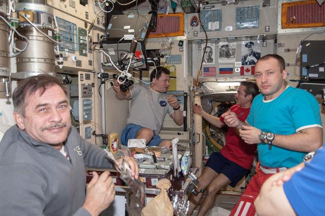 Expedition 35 Crewmembers share a meal in the SM