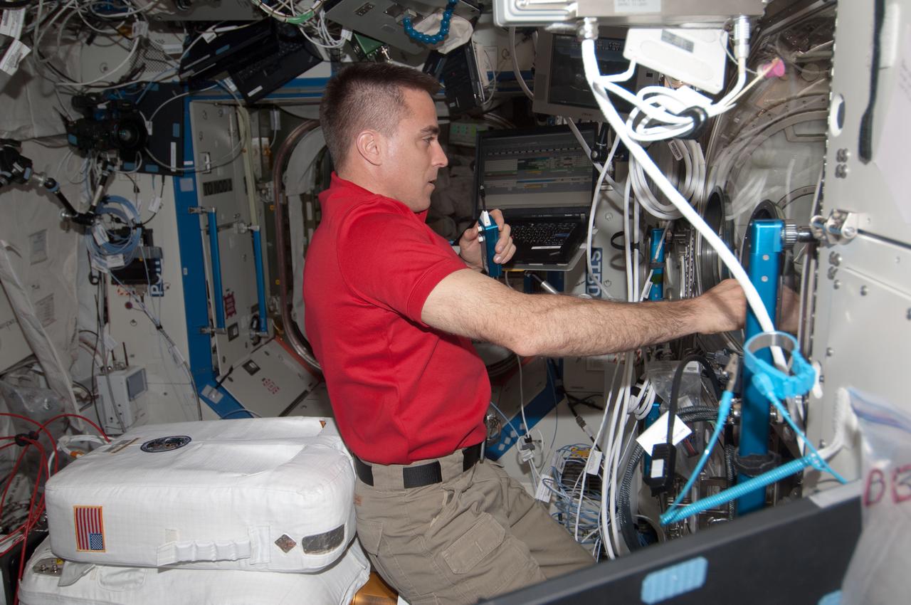 ISS035-E-16429 (9 April 2013) --- Astronaut Chris Cassidy, Expedition 35 flight engineer, conducts a session of the Burning and Suppression of Solids (BASS) experiment located in the U.S. lab Destiny onboard the Earth-orbiting International Space Station.  Cassidy over a period of several days, has conducted several "runs" of the experiment, which examines the burning and extinction characteristics of a wide variety of fuel samples in microgravity and will guide strategies for extinguishing fires in microgravity. BASS results contribute to the combustion computational models used in the design of fire detection and suppression systems in microgravity and on Earth.