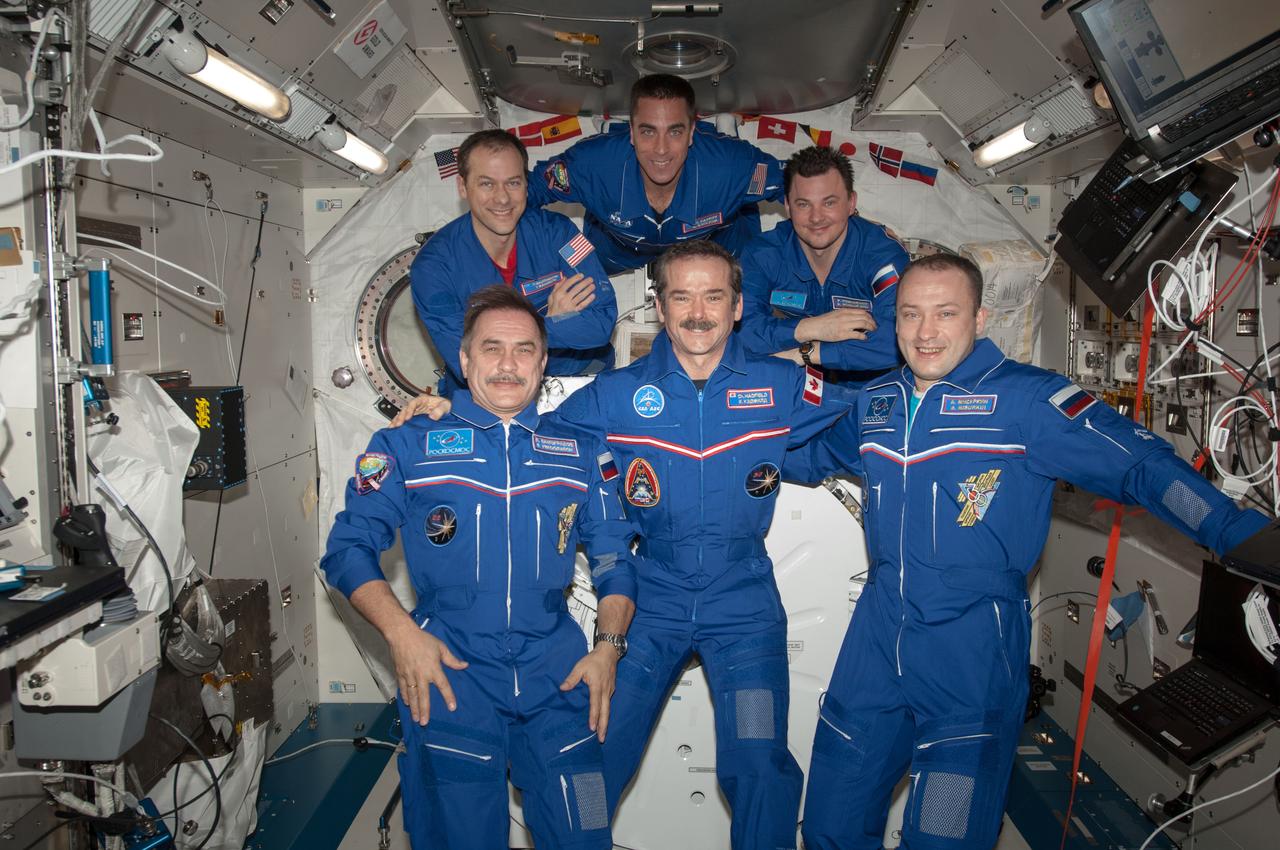 Expedition 35 crewmembers pose for an in-flight portrait in the Kibo Japanese Experiment Pressurized Module (JPM). From left, are (front row) flight engineer (FE) Pavel Vinogradov, commander Chris Hadfield, FE Alexander Misurkin, (back row) FE Tom Marshburn, FE Chris Cassidy, and FE Roman Romanenko. Vinogradov, Misurkin and Romanenko are Roscosmos cosmonauts; Hadfield is a Canadian Space Agency (CSA) astronaut.