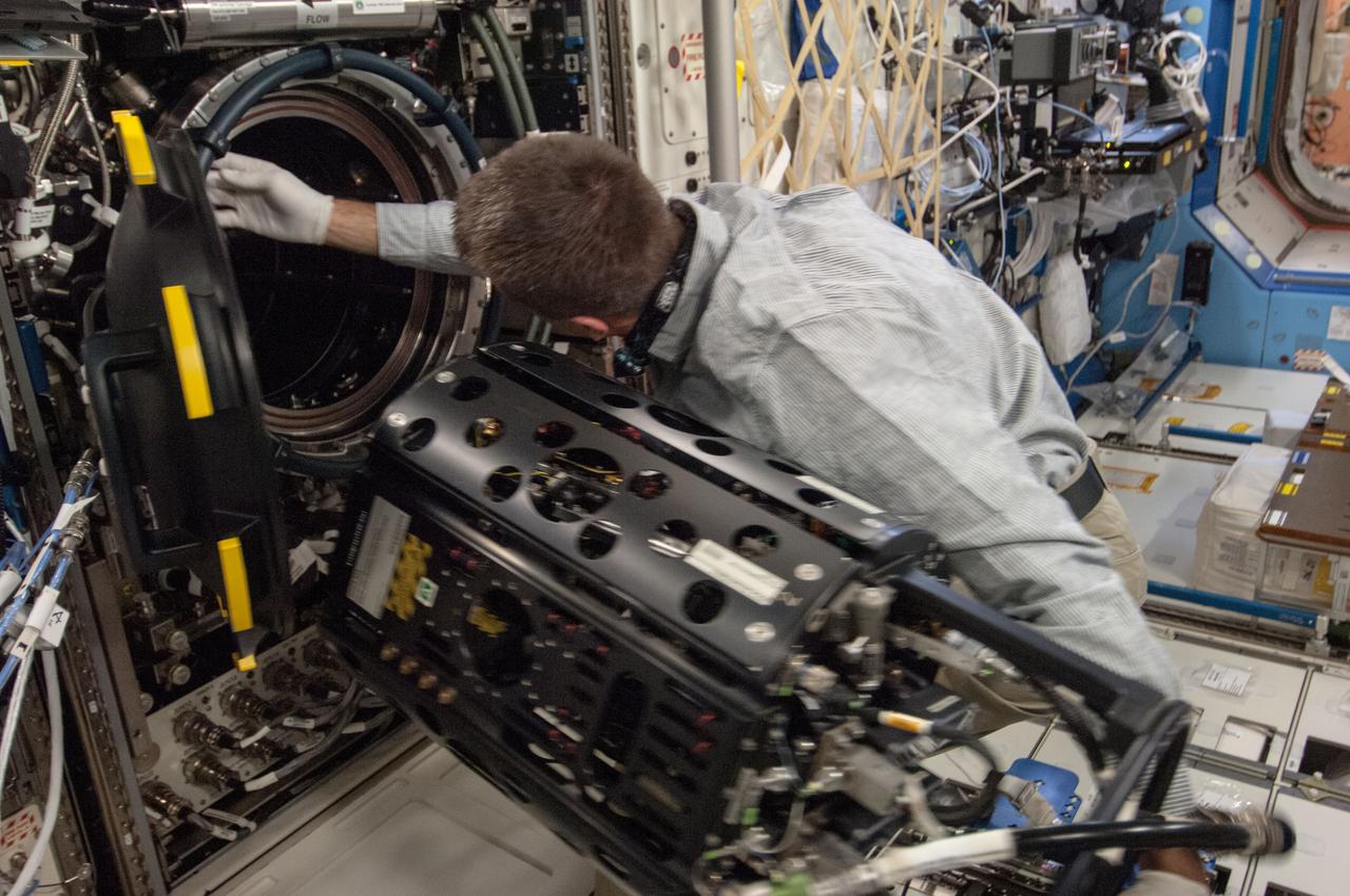 ISS035-E-017699 (10 April 2013) --- This is one of several photos documenting the Multi-user Droplet Combustion Apparatus (MDCA) Fuel Reservoir replacement. Here, Expedition 35 Flight Engineer Chris Cassidy removes and replaces one of the Fuel Reservoirs with the MDCA Chamber Insert Assembly (CIA) pulled partially out of the Combustion Chamber. The MDCA Fuel Reservoirs contain the liquid fuel used during droplet combustion experiments. This reservoir change-out was in support of the FLame EXtinguishment (FLEX)-2 experiment, scheduled to be executed by ground controllers.