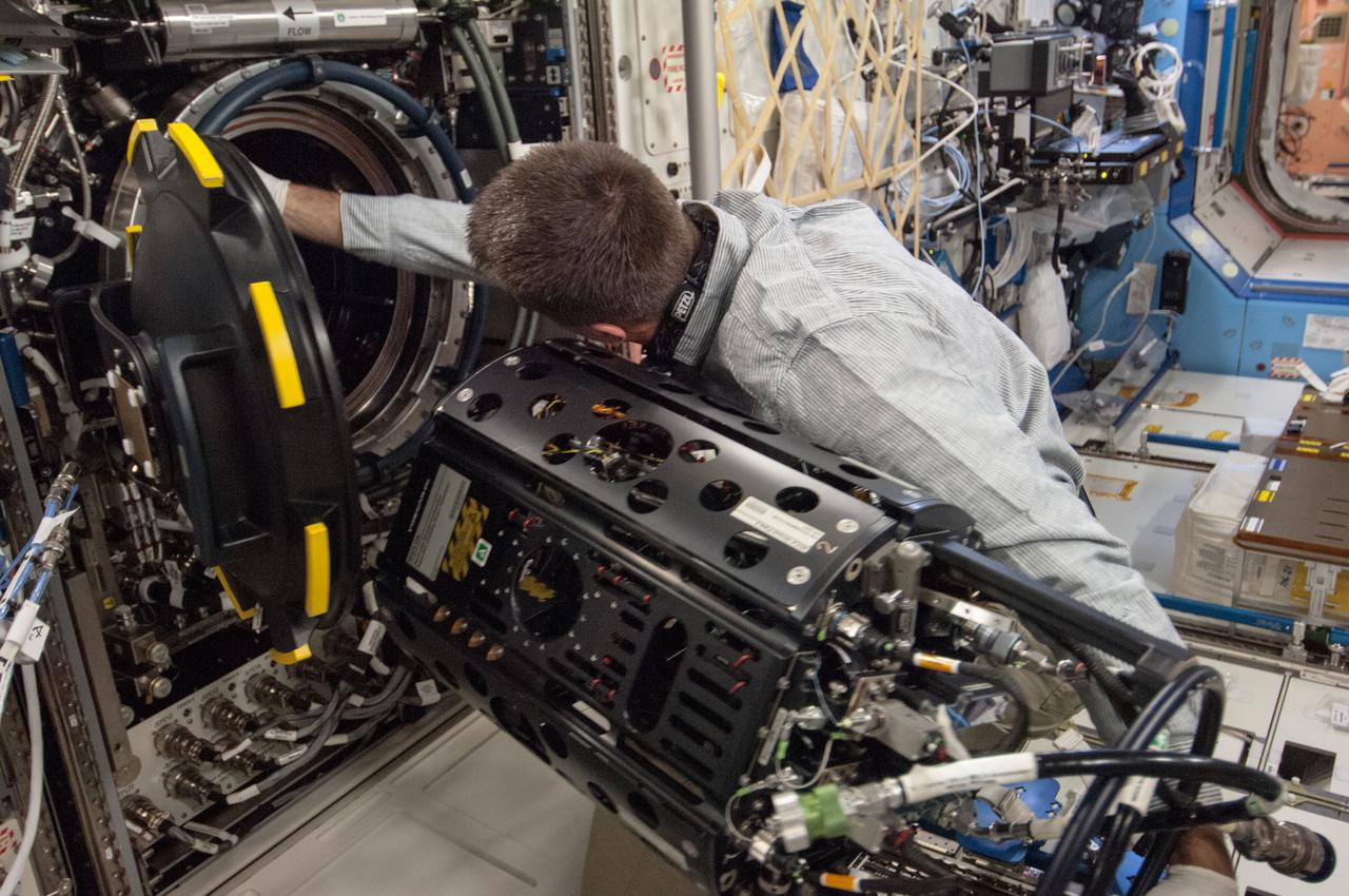ISS035-E-017699 (10 April 2013) --- This is one of several photos documenting the  Multi-user Droplet Combustion Apparatus (MDCA) Fuel Reservoir replacement.  Here, Expedition 35 Flight Engineer Chris Cassidy removes and replaces one of the Fuel Reservoirs with the MDCA Chamber Insert Assembly (CIA) pulled partially out of the Combustion Chamber. The MDCA Fuel Reservoirs contain the liquid fuel used during droplet combustion experiments.   This reservoir change-out was in support of the FLame EXtinguishment (FLEX)-2 experiment, scheduled to be executed by ground controllers.