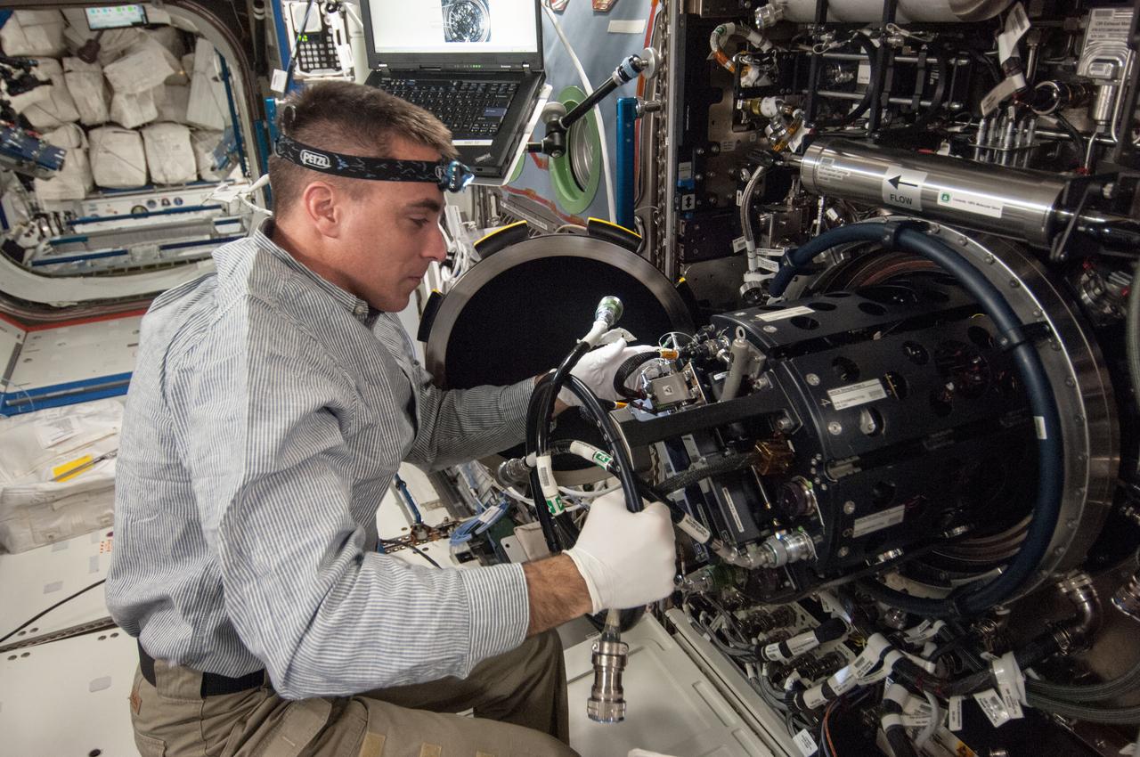 ISS035-E-017712 (10 April 2013)?-- This is one of several photos documenting the  Multi-user Droplet Combustion Apparatus (MDCA) Fuel Reservoir replacement in the U.S. lab Destiny.  Here, Expedition 35 Flight Engineer Chris Cassidy removes and replaces one of the Fuel Reservoirs with the MDCA Chamber Insert Assembly (CIA) pulled partially out of the Combustion Chamber. The MDCA Fuel Reservoirs contain the liquid fuel used during droplet combustion experiments.   This reservoir change-out was in support of the FLame EXtinguishment (FLEX)-2 experiment, scheduled to be executed by ground controllers.