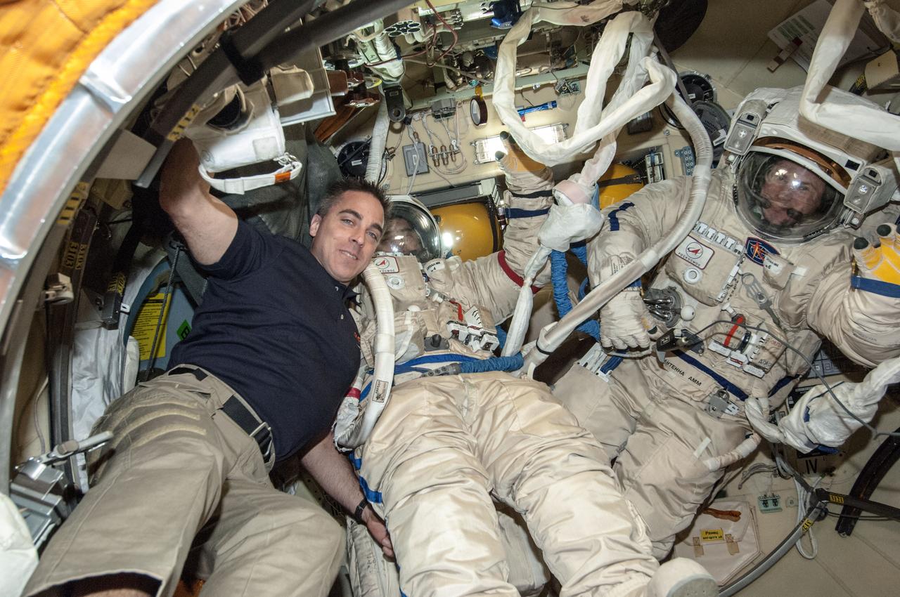 ISS035-E-022379 (17 April 2013) --- Russian cosmonauts Pavel Vinogradov (center) and Roman Romanenko (right) donned their Orlan spacesuits once again on the International Space Station on April 17. The two are seen with NASA astronaut Chris Cassidy outside the Pirs Docking Compartment airlock during a suited ?dry run? dress rehearsal of the procedures they will conduct during a scheduled April 19 spacewalk. Cassidy will remain inside the orbiting complex throughout the spacewalk.