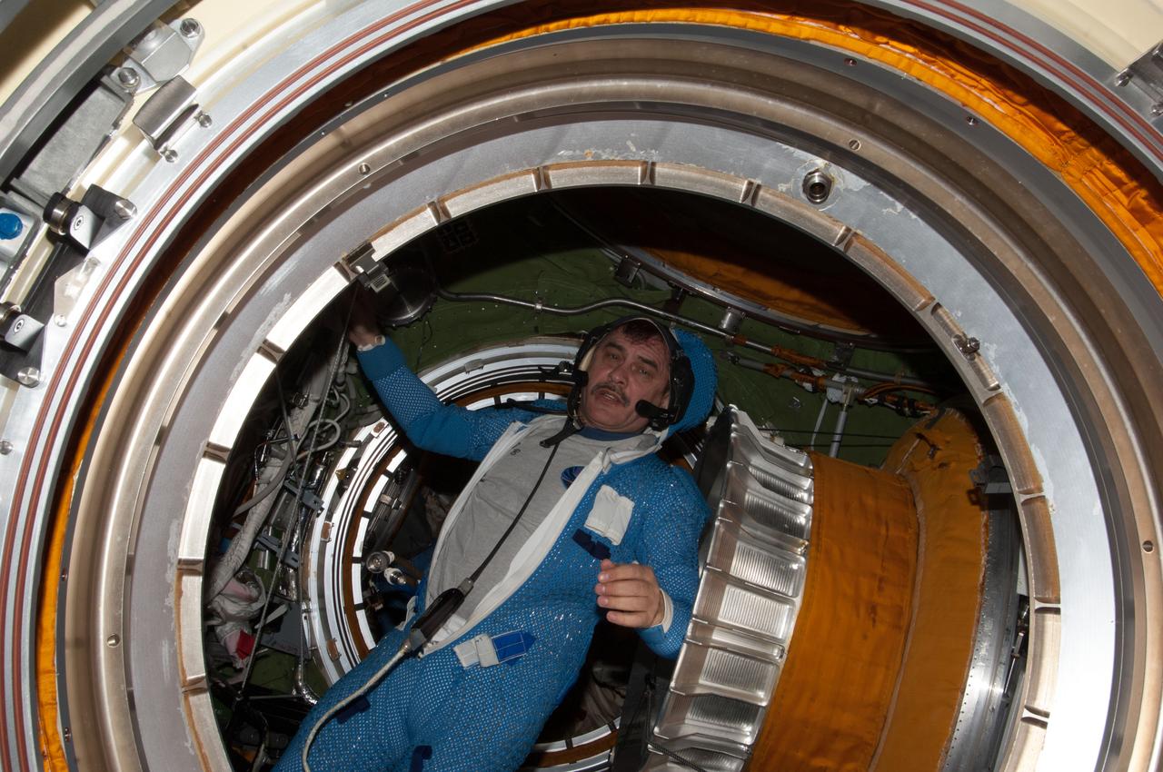ISS035-E-023770 (19 April 2013) --- Prior to the first extravehicular activity of Expedition 35, Russian cosmonaut Pavel Vinogradov, flight engineer, is seen in the International Space Station's Zvezda service module transfer compartment, as photographed from Poisk, looking through the transfer compartment and toward Pirs. Vinogradov is attired in the thermal undergarment for the Orlan spacesuit, which he has yet to don.  Vinogradov and fellow cosmonaut Roman Romanenko went on to spend about six hours performing upgrade work on exterior hardware.