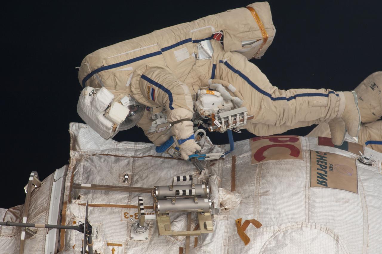 iss035e023973 (4/19/2013) --- Extravehicular crewmember 2 (EV2) Roman Romanenko works to retrieve Biorisk-MSN experiment Container 2 from the Pirs Docking Compartment (DC1) during Russian Extravehicular Activity 32 (EVA 32).