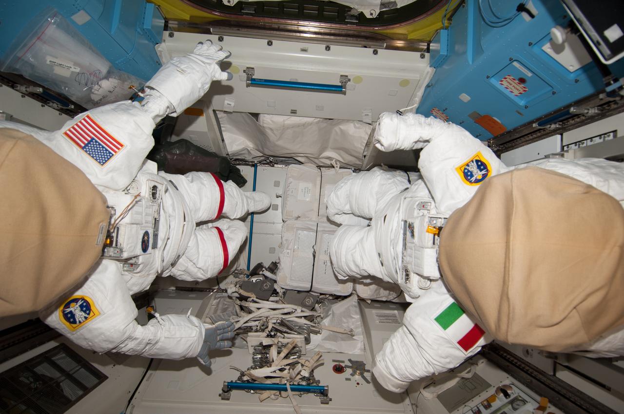 ISS035-E-030111 (28 April 2013) --- This high-angle view in the Quest airlock aboard the Earth-orbiting International Space Station portends a spacewalk for  the Expedition 36 crew later in the year. Two extravehicular mobility units (EMU) stand ready for the event. U.S. and Italian flags on the shoulders of the suits signal that the participating astronauts would be representing NASA and the European Space Agency (ESA). Actually, NASA astronaut Chris Cassidy, now serving as a member of the Expedition 35 crew;  and Luca Parmitano of ESA, who is currently still on Earth getting ready for a May launch,  are scheduled for two spacewalks together in the summer of this year.