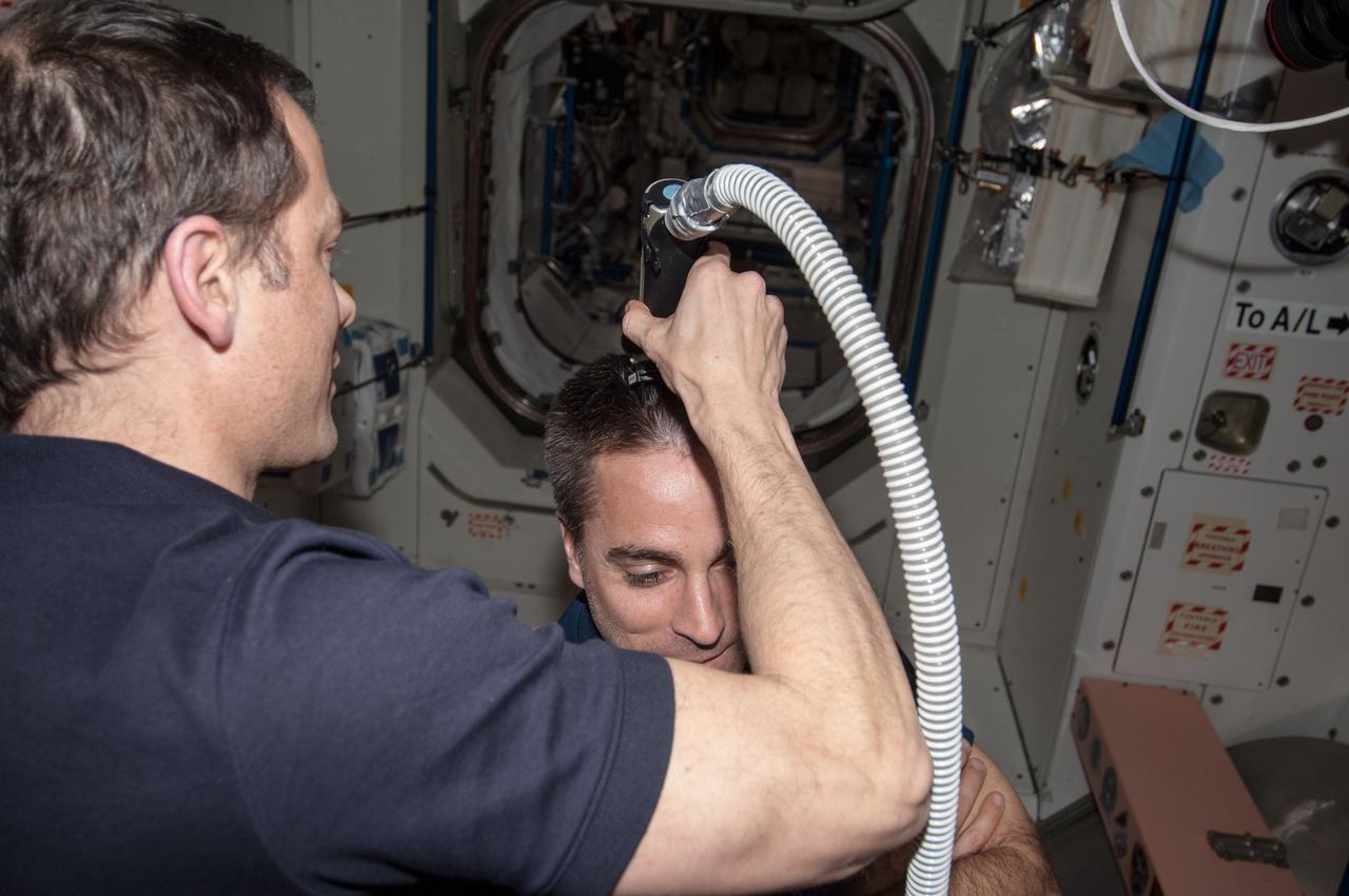 ISS035-E-030120 (28 April 2013) --- Most of the six Expedition 35 crew members got haircuts on April 28 in the Unity node of the Earth-orbiting International Space Station. Here, NASA astronaut Tom Marshburn prepares to trim the head of Russian cosmonaut Alexander Misurkin.