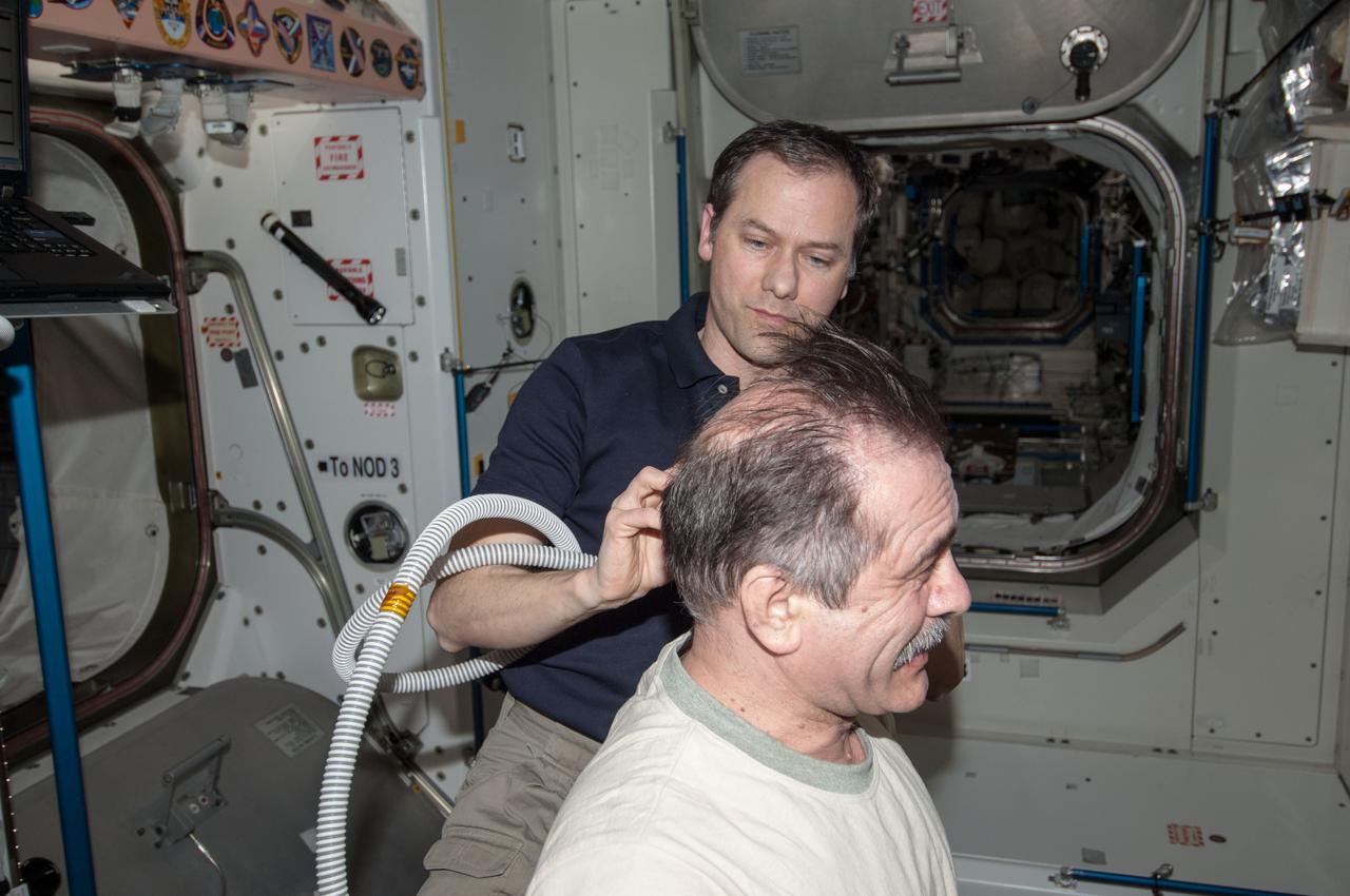 ISS035-E-030128 (28 April 2013) --- Most of the six Expedition 35 crew members got haircuts on April 28 in the Unity node of the Earth-orbiting International Space Station. Here, NASA astronaut Tom Marshburn trims the head of Russian cosmonaut Pavel Vinogradov.