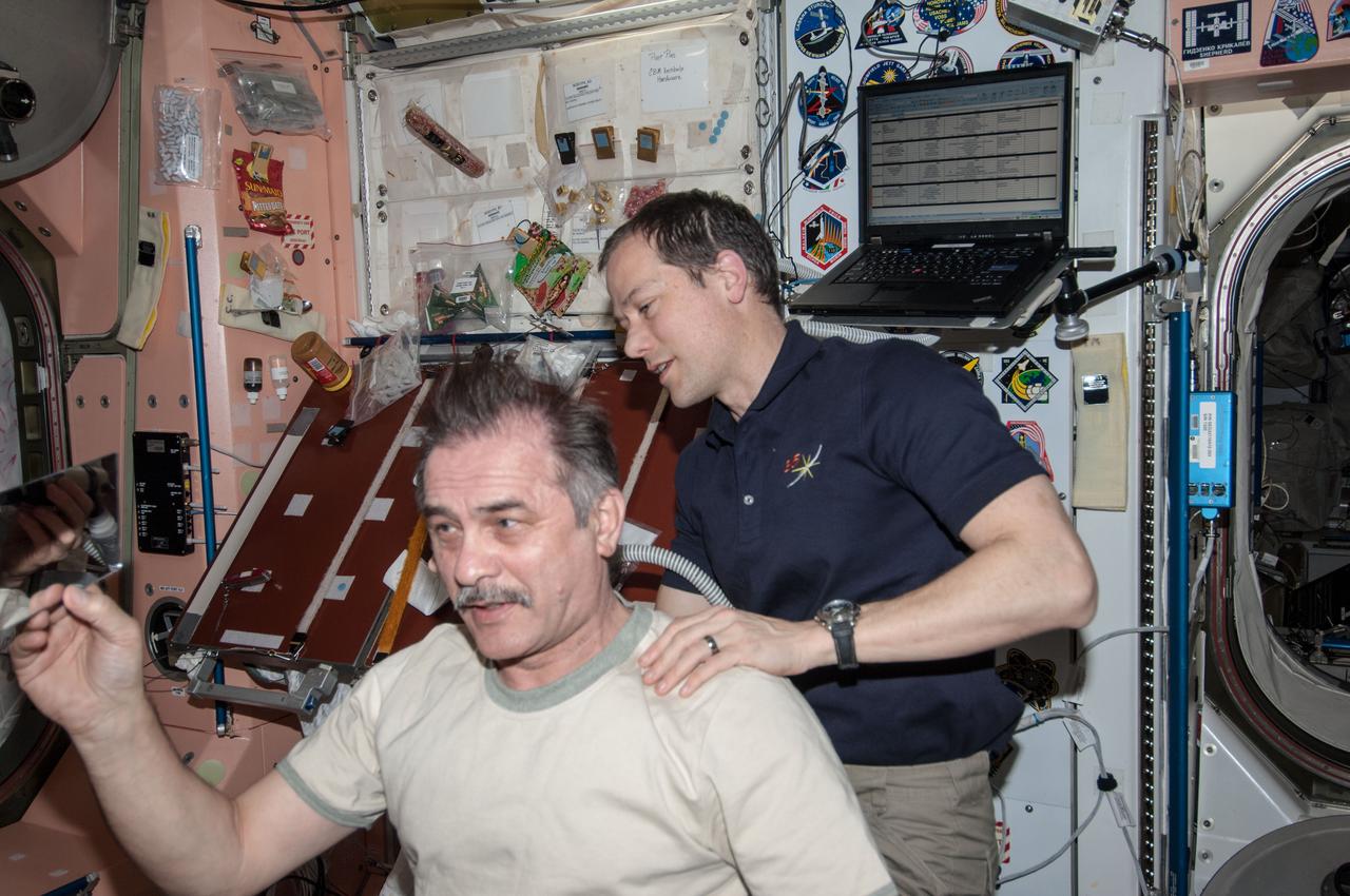 ISS035-E-030128 (28 April 2013) --- Most of the six Expedition 35 crew members got haircuts on April 28 in the Unity node of the Earth-orbiting International Space Station. Here, NASA astronaut Tom Marshburn trims the head of Russian cosmonaut Pavel Vinogradov.