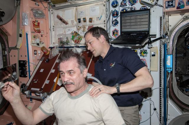 NASA image: Marshburn gives Vinogradov a haircut in Node 1