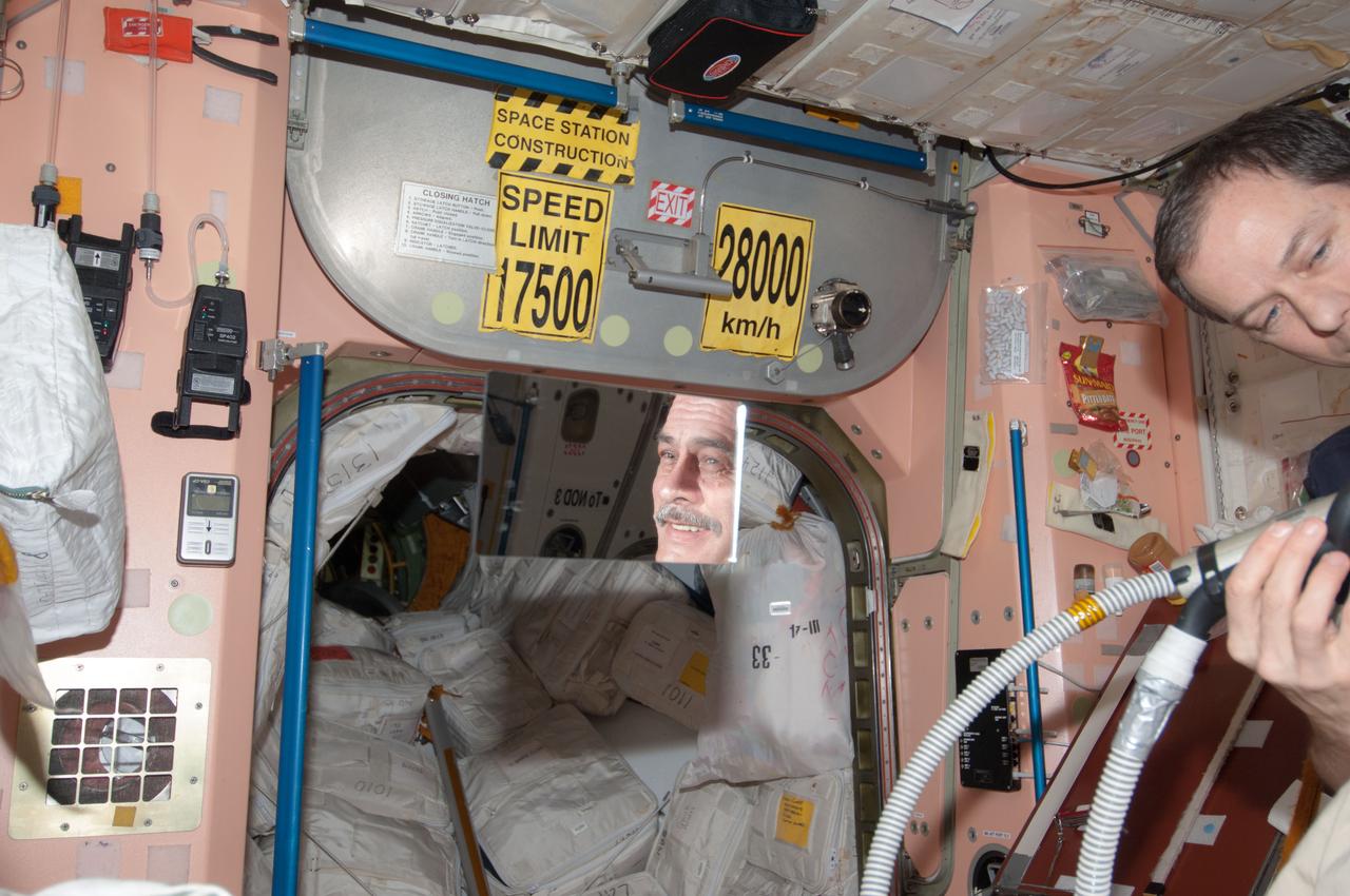 ISS035-E-030128 (28 April 2013) --- Most of the six Expedition 35 crew members got haircuts on April 28 in the Unity node of the Earth-orbiting International Space Station. Here, NASA astronaut Tom Marshburn trims the head of Russian cosmonaut Pavel Vinogradov.