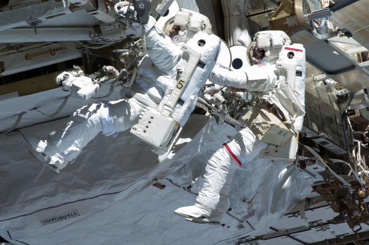 ISS035-E-037725 (11 May 2013) --- Expedition 35 Flight Engineers Chris Cassidy (right) and Tom Marshburn completed a space walk at 2:14 p.m. EDT May 11 to inspect and replace a pump controller box on the International Space Station's far port truss (P6) leaking ammonia coolant. The two NASA astronauts began the 5-hour, 30-minute space walk at 8:44 a.m.