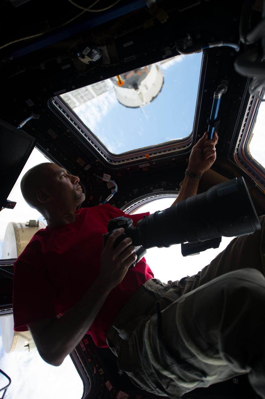 ISS036-E-005774 (2 June 2013) --- Inside the Cupola, European Space Agency astronaut Luca Parmitano, an Expedition 36 flight engineer, eyeballs a point on Earth some 250 miles below him and the International Space Station before pinpointing a specific photo target of opportunity. He holds a digital still camera, equipped with a 400mm lens. Parmitano has been on board the orbital outpost for about three days and will continue his stay into November