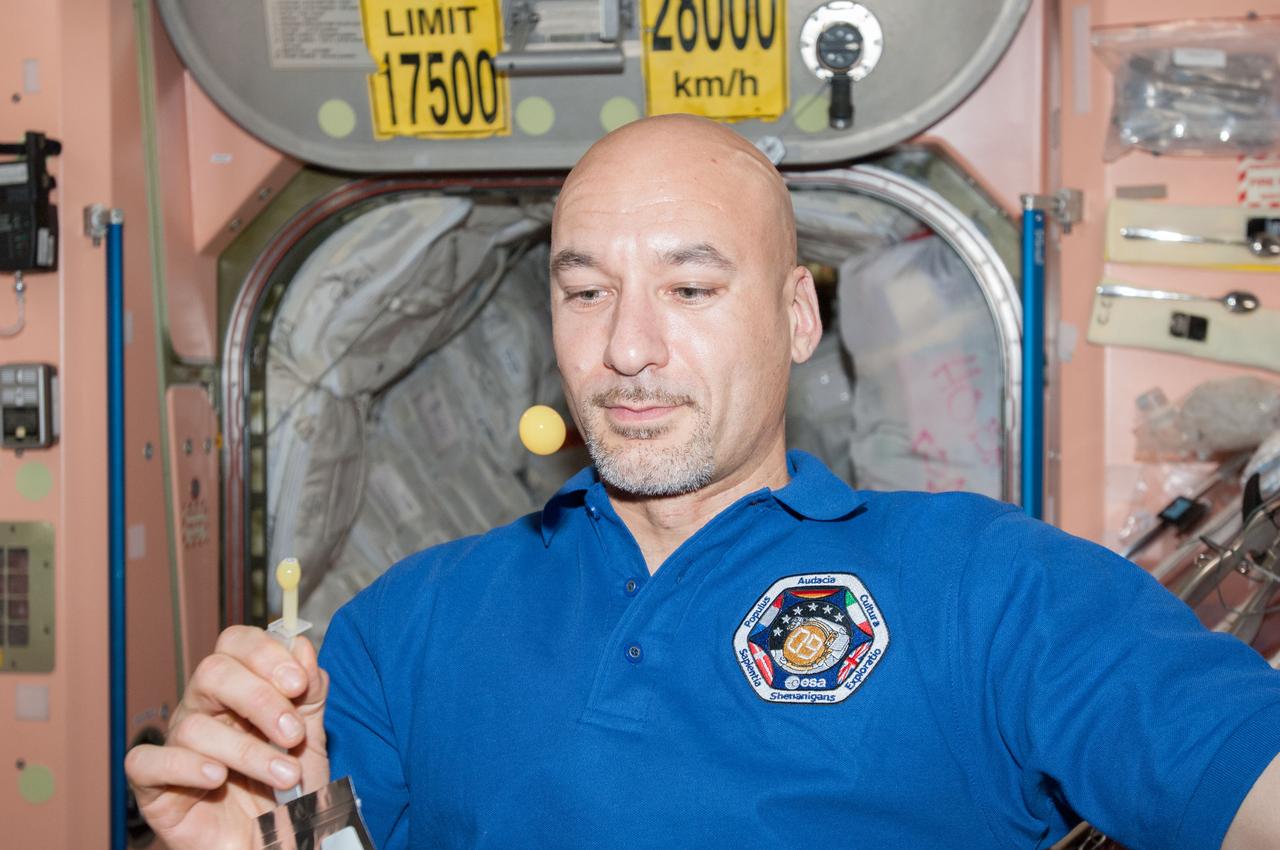 ISS036-E-007249 ( June 2013) --- European Space Agency astronaut Luca Parmitano, Expedition 36 flight engineer, creates a bubble of orange juice from a beverage dispenser in the Unity node during some of his off-duty time aboard the Earth-orbiting International Space Station. Parmitano is scheduled to stay aboard the orbital outpost until November.