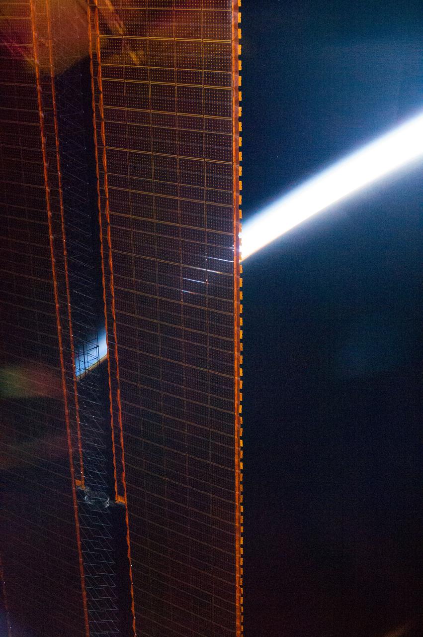ISS036-E-007619 (13 June 2013) --- To a crew member aboard the International Space Station, the home planet is seen from many different angles and perspectives, as evdenced by this Expedition 36 image of Earth's atmophere partially obscured by one of the orbital outpost's solar panels.