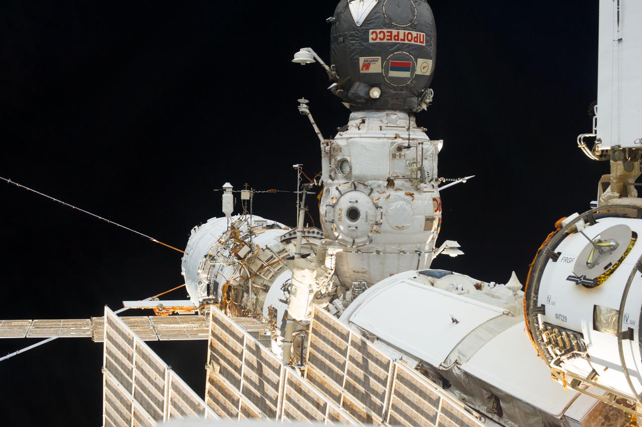 View of  Russian cosmonaut Alexander Misurkin (bottom center), Expedition 36 flight engineer, participating in Russian extravehicular activity (EVA) 33. Also visible are the  Progress spacecraft docked to the Pirs Docking Compartment (DC1) with the Service Module (SM) .