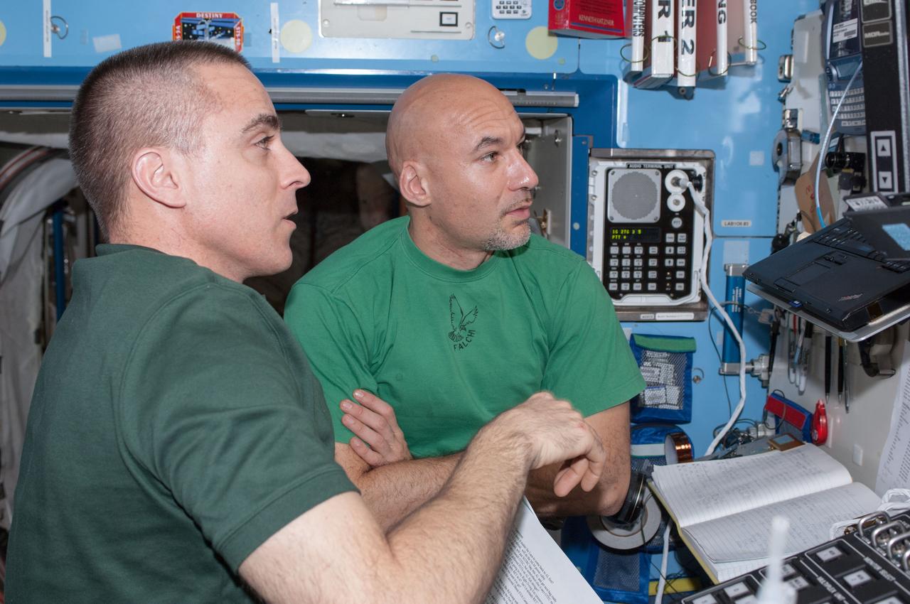 ISS036-E-012130 (25 June 2013) --- NASA astronaut Chris Cassidy (left) and European Space Agency astronaut Luca Parmitano, both Expedition 36 flight engineers, perform a Portable Onboard Computers (POC) Dynamic Onboard Ubiquitous Graphics (DOUG) software review in preparation for spacewalks scheduled for July 9 and July 16.