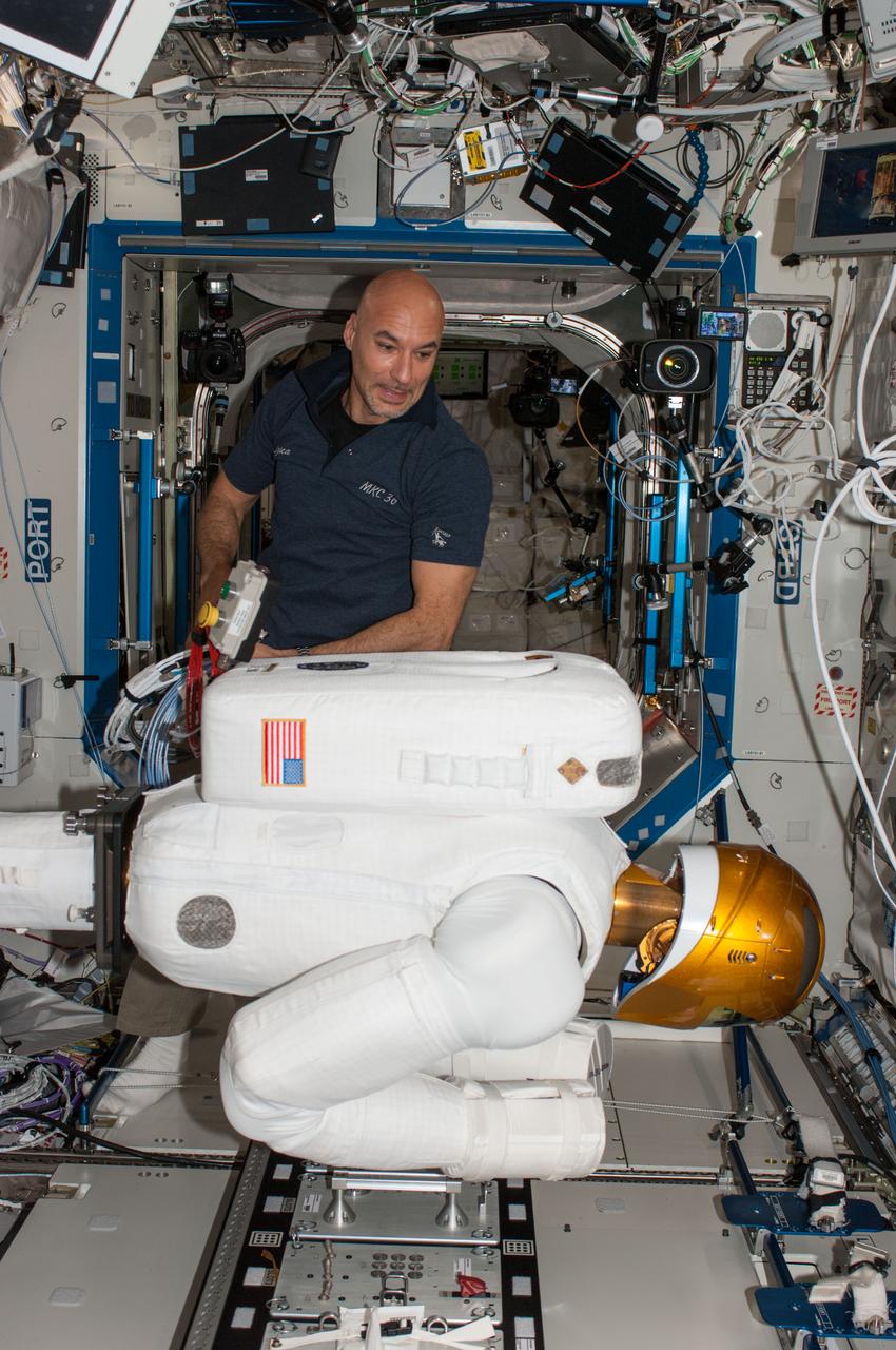 ISS036-E-012571 (27 June 2013) --- European Space Agency astronaut Luca Parmitano, Expedition 36 flight engineer, works with Robonaut 2, the first humanoid robot in space, during a round of ground-commanded tests in the Destiny laboratory of the International Space Station. R2 was assembled earlier this week for several days of data takes by the payload controllers at the Marshall Space Flight Center.