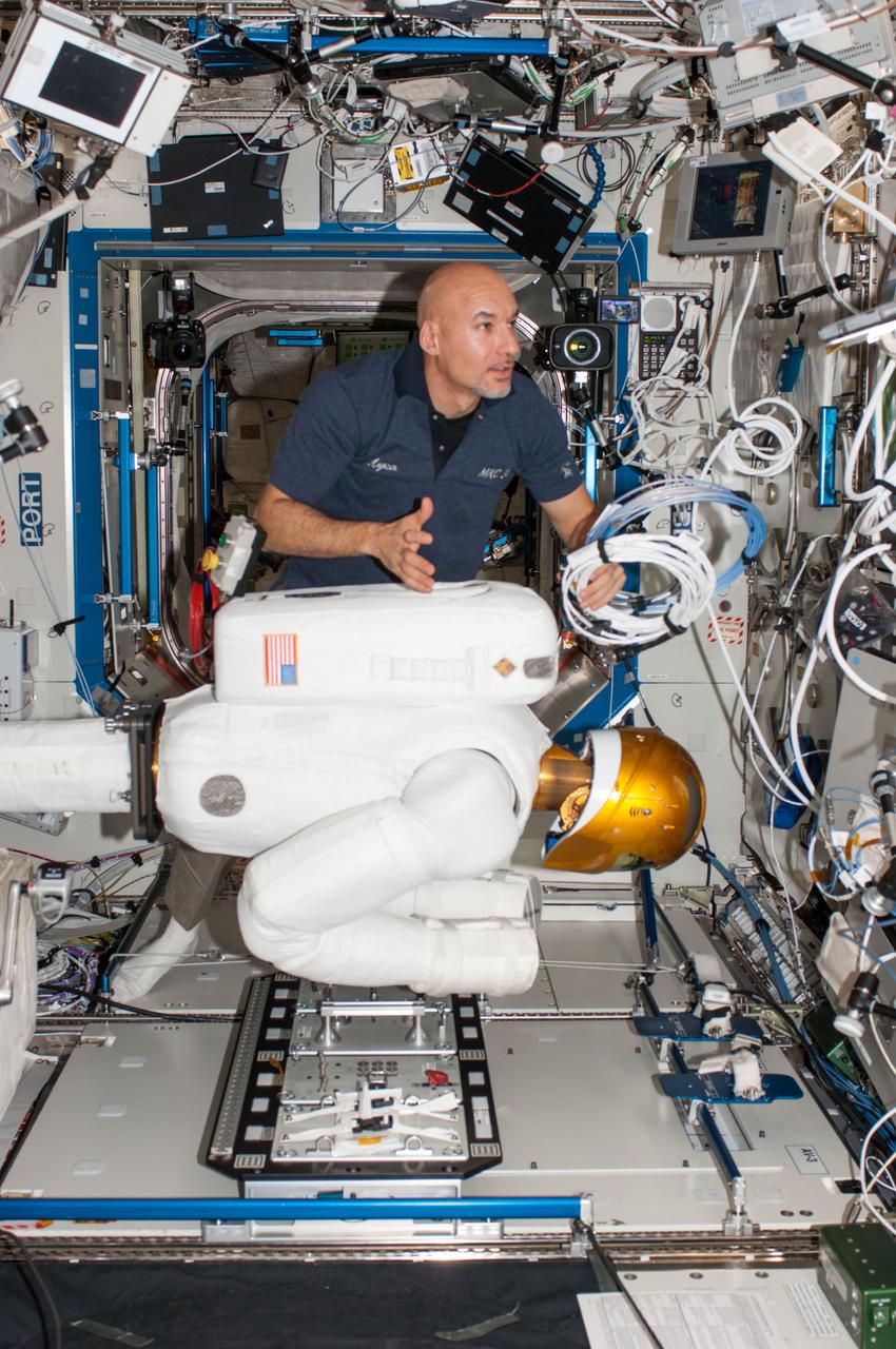 ISS036-E-012573 (27 June 2013) --- European Space Agency astronaut Luca Parmitano, Expedition 36 flight engineer, works with Robonaut 2, the first humanoid robot in space, during a round of ground-commanded tests in the Destiny laboratory of the International Space Station. R2 was assembled earlier this week for several days of data takes by the payload controllers at the Marshall Space Flight Center.