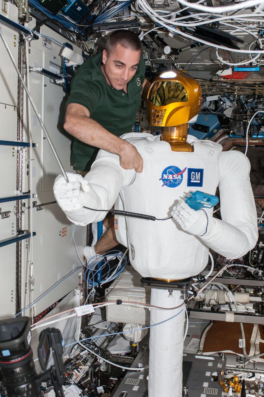 ISS036-E-013172 (28 June 2013) --- NASA astronaut Chris Cassidy, Expedition 36 flight engineer, works with Robonaut 2, the first humanoid robot in space, during a round of ground-commanded tests in the Destiny laboratory of the International Space Station. R2 was assembled earlier this week for several days of data takes by the payload controllers at the Marshall Space Flight Center.