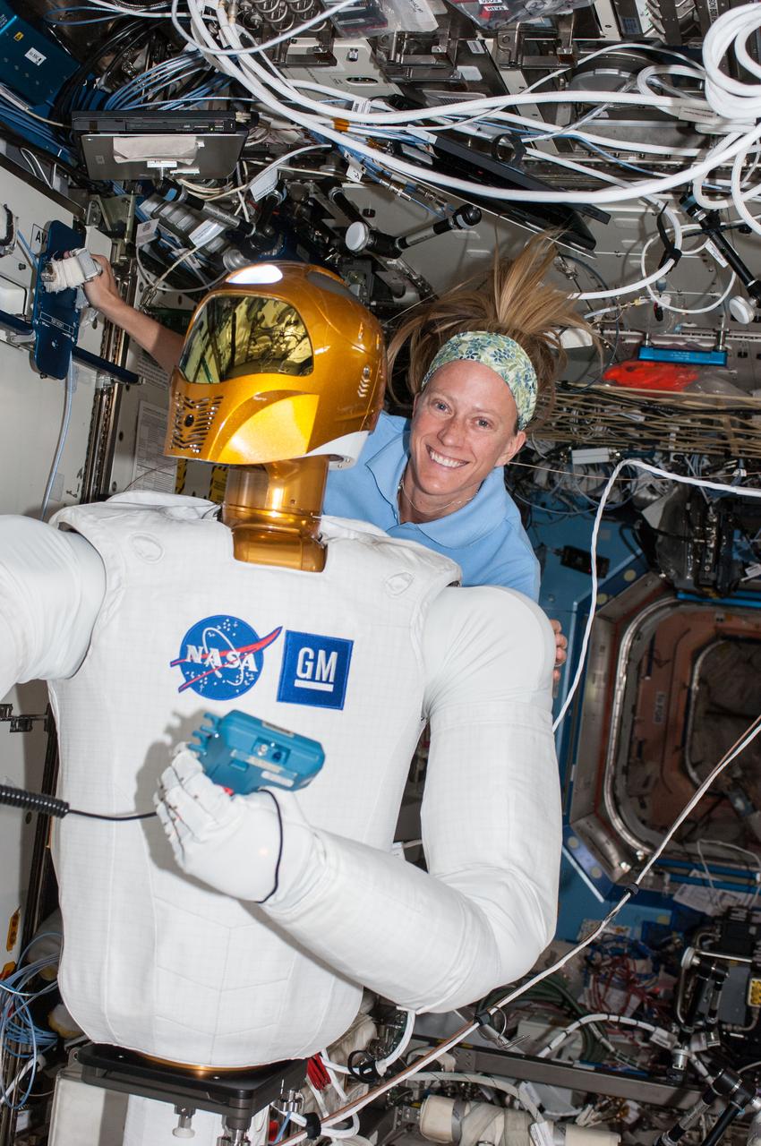 ISS036-E-013175 (28 June 2013) --- NASA astronaut Karen Nyberg, Expedition 36 flight engineer, is pictured with Robonaut 2, the first humanoid robot in space, in the Destiny laboratory of the International Space Station.