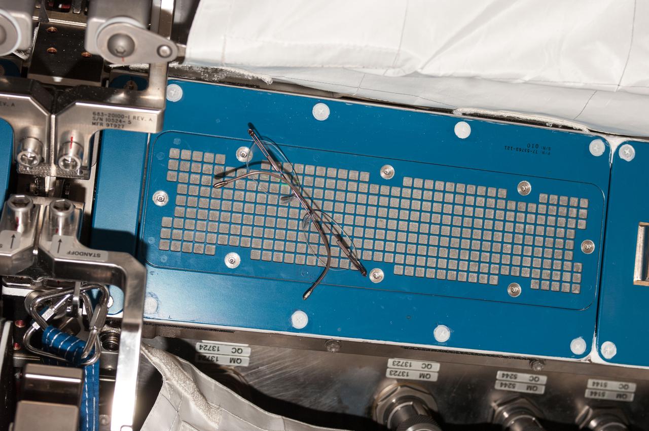Candid view of a pair of eye glasses,floating in front of a ventilation filter in the Japanese Experiment Module (JEM).
