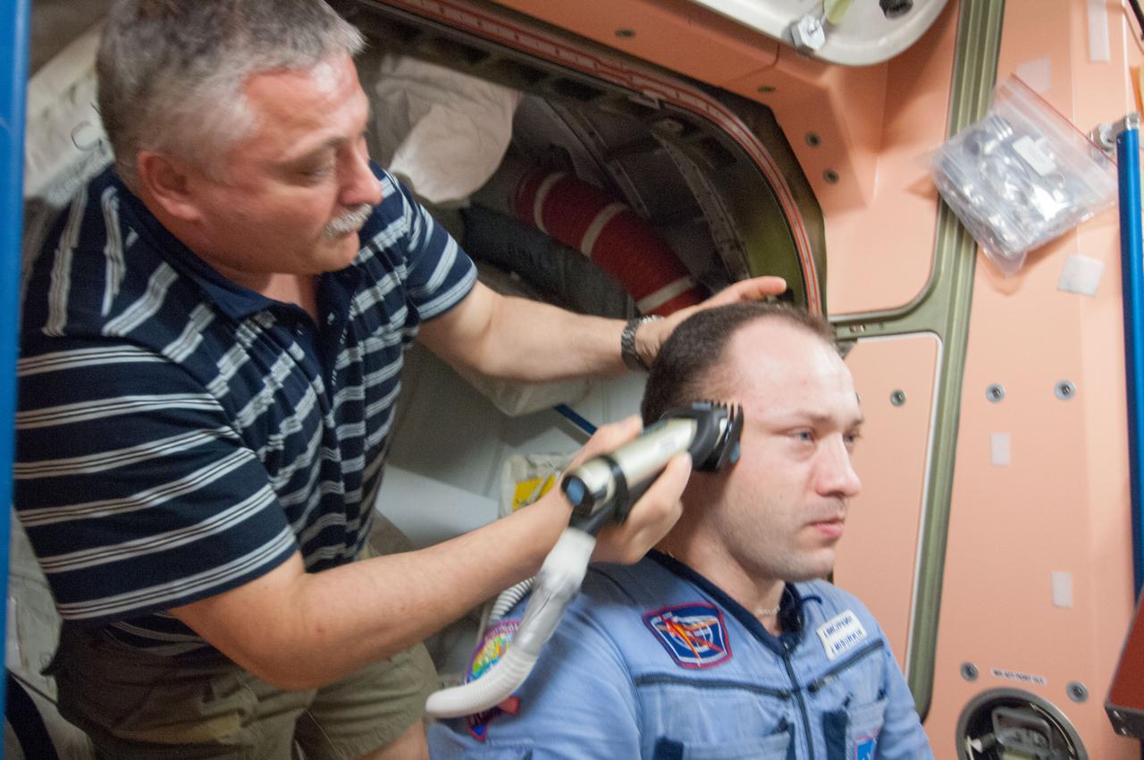 ISS036-E-014568 (4 July 2013) --- Russian cosmonaut Fyodor Yurchikhin, Expedition 36 flight engineer, trims the hair of Russian cosmonaut Alexander Misurkin, flight engineer, in the Unity node of the International Space Station. Yurchikhin used hair clippers fashioned with a vacuum device to garner freshly cut hair.