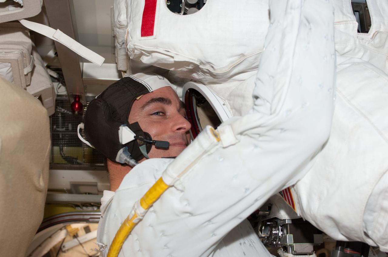 ISS036-E-014640 (3 July 2013) --- NASA astronaut Chris Cassidy, Expedition 36 flight engineer, prepares to don his Extravehicular Mobility Unit (EMU) spacesuit during a ?dry run? in the International Space Station?s Quest airlock in preparation for the first of two sessions of extravehicular (EVA) scheduled for July 9 and July 16. Cassidy is wearing a liquid cooling and ventilation garment that complements the EMU.